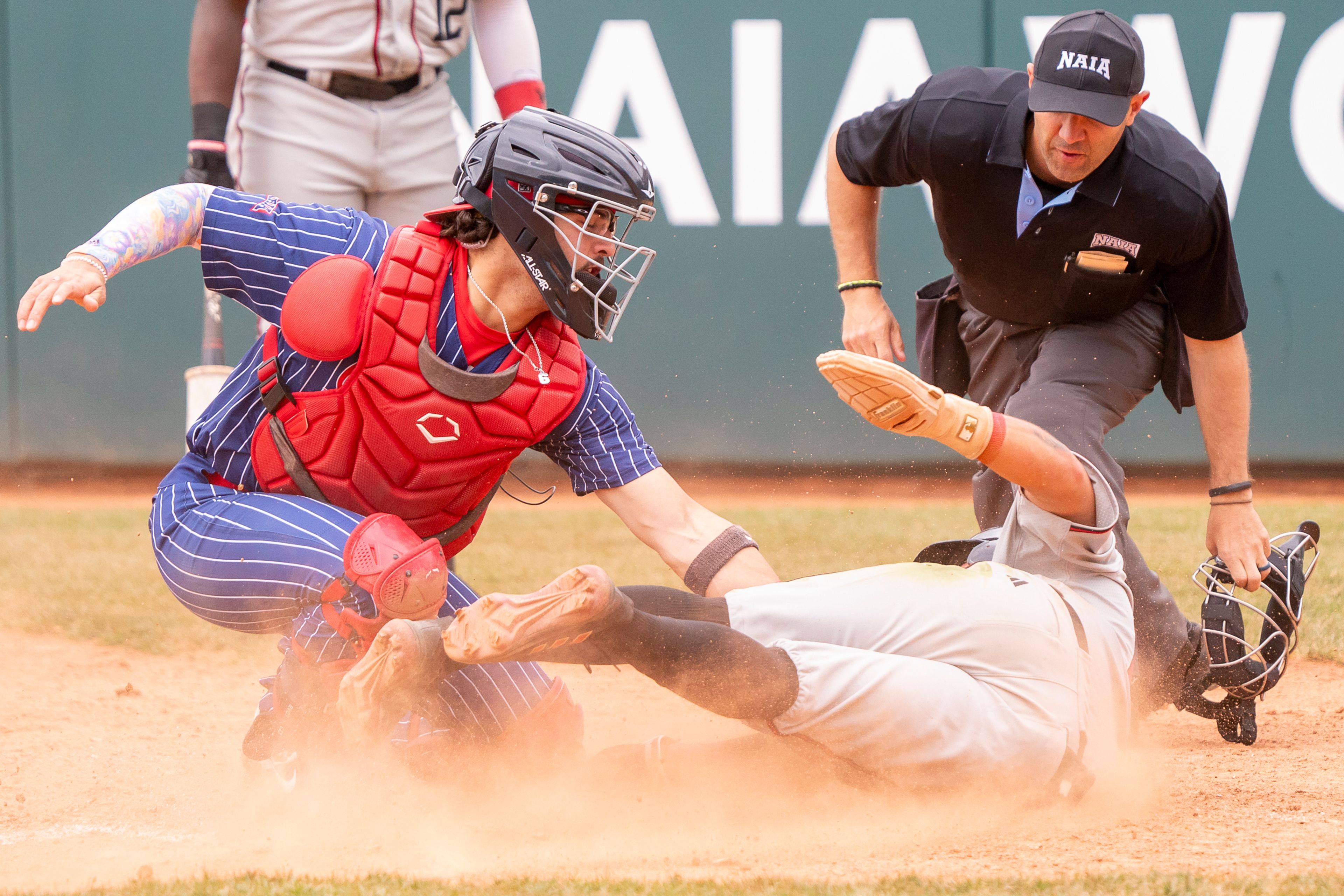 Cumberlands catcher Charlie Muñiz, left, tags out William Carey’s Rigoberto Hernandez at home during game 6 of the NAIA World Series on Saturday at Harris Field in Lewiston.