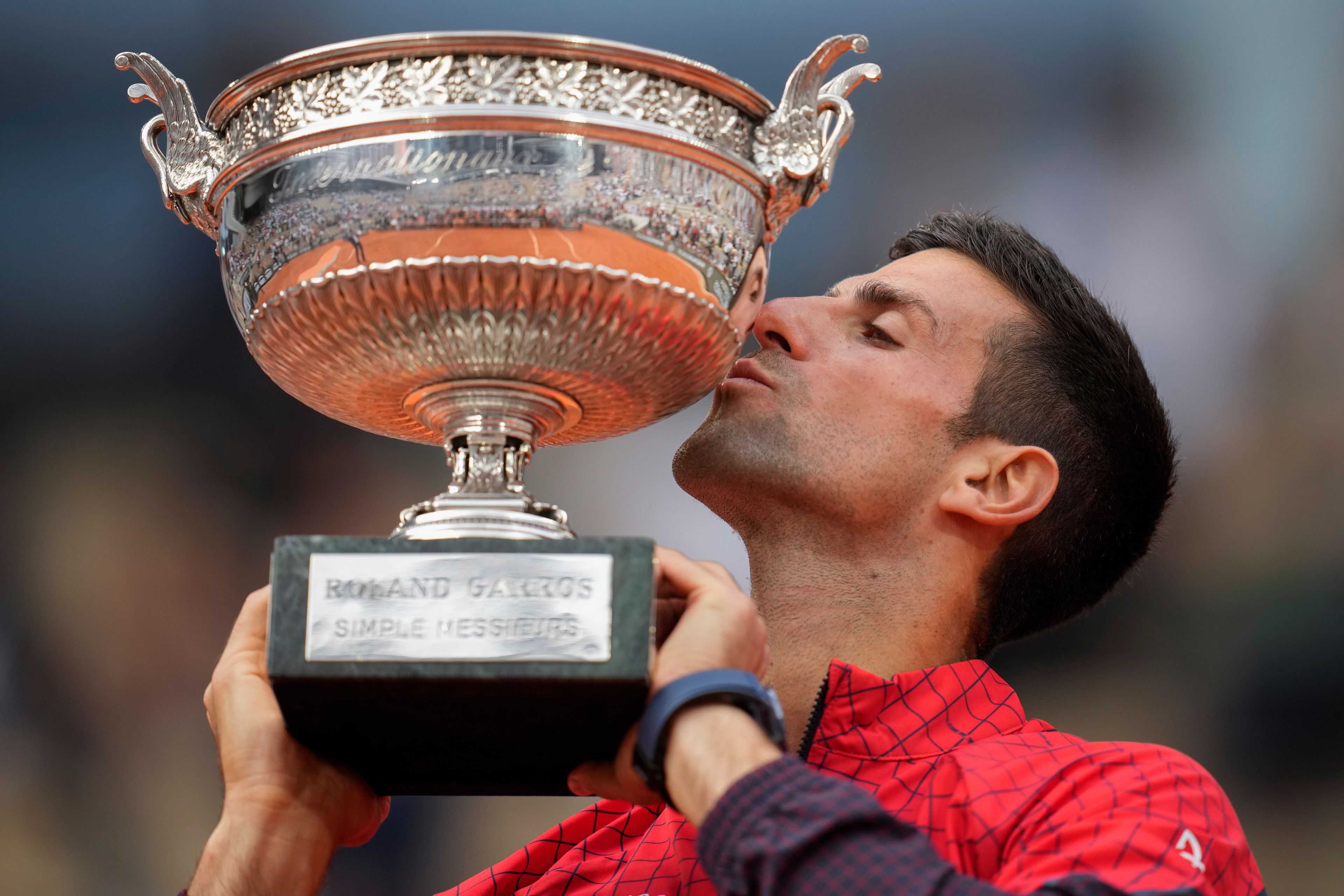 FILE - Serbia's Novak Djokovic kisses the trophy as he celebrates winning the men's singles final match of the French Open tennis tournament against Norway's Casper Ruud at Roland Garros stadium in Paris, Sunday, June 11, 2023. Djokovic won three of his men’s-record 24 Grand Slam titles at the French Open, which starts Sunday at Roland Garros in Paris.