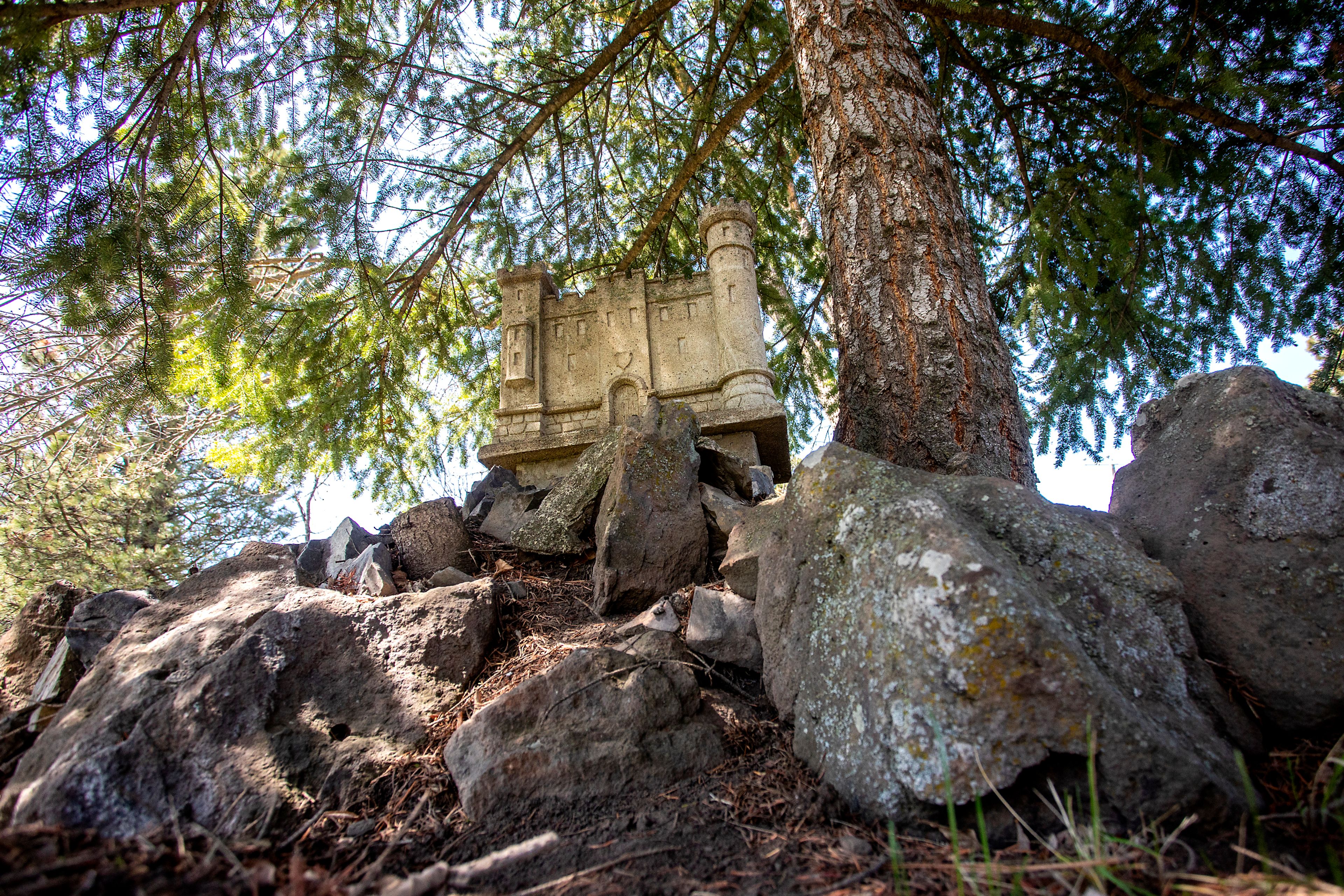 A miniture model of a building sits among some rocks nearby a tree in the front yard of the St. Gertrude Monastery near Cottonwood.