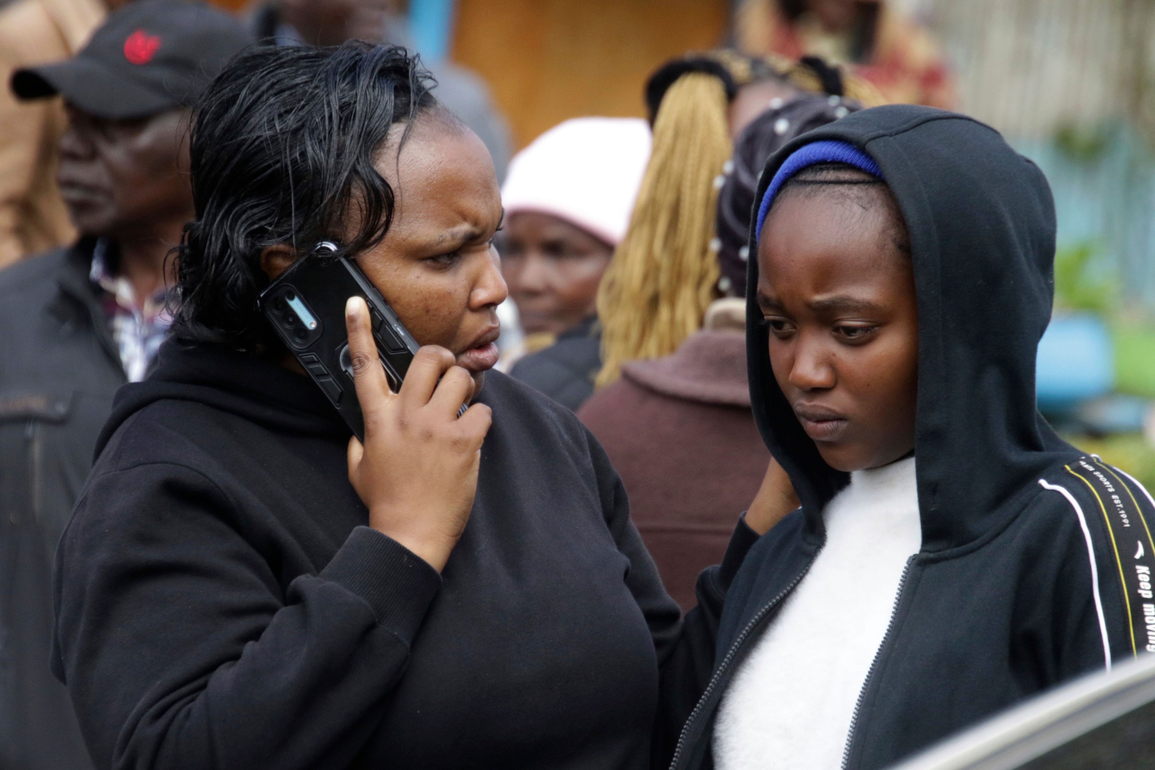 Distressed parents and relatives stand near a burned-out dormitory, following a fire at the Hillside Endarasha Primary in Nyeri, Kenya Friday, Sept. 6, 2024.