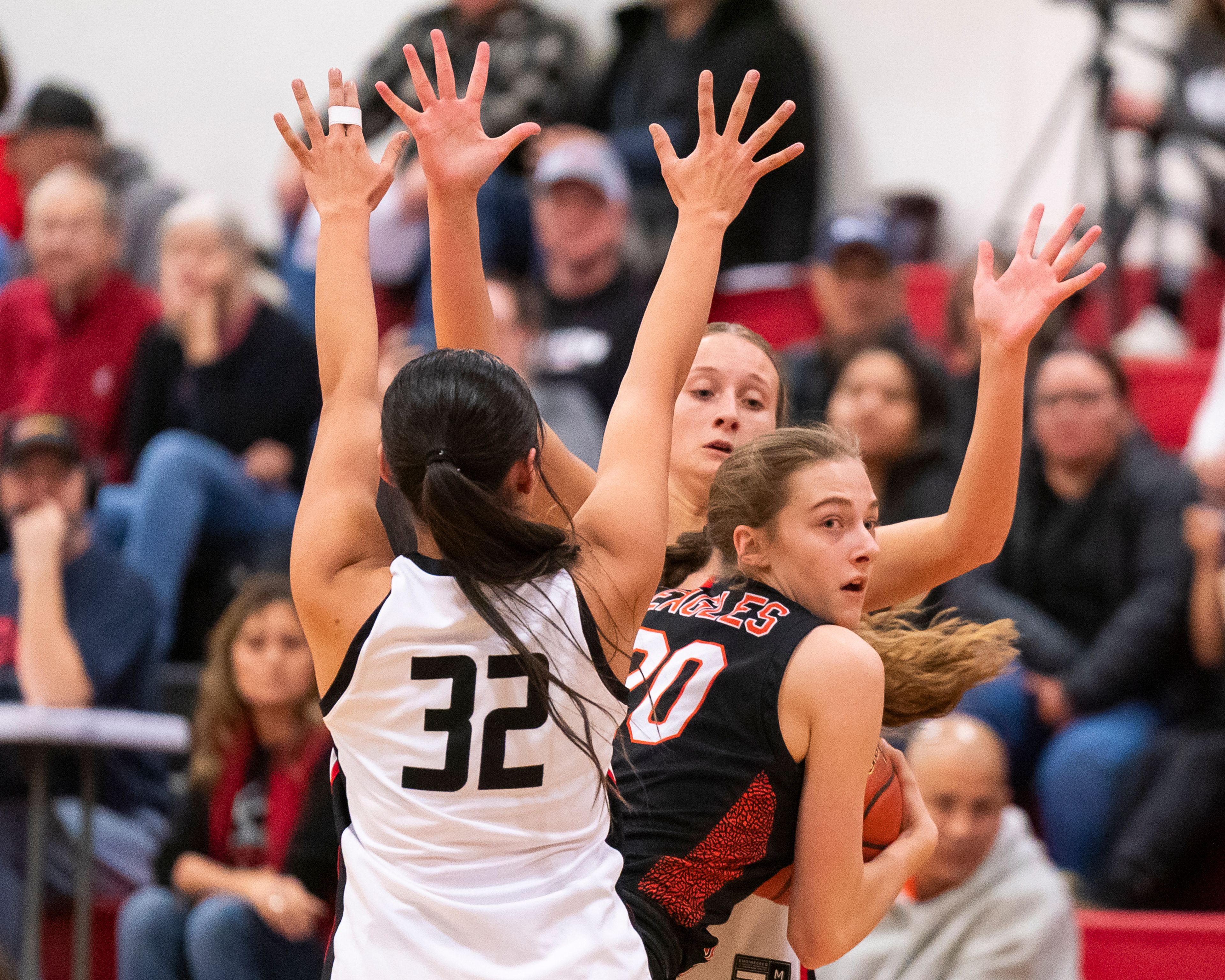 Clarkston’s Lexi Villavicencio (32) and Olivia Gustafson (5) double team West Valley’s Addison McIntyre (20) during their game on Tuesday at Clarkston High School.