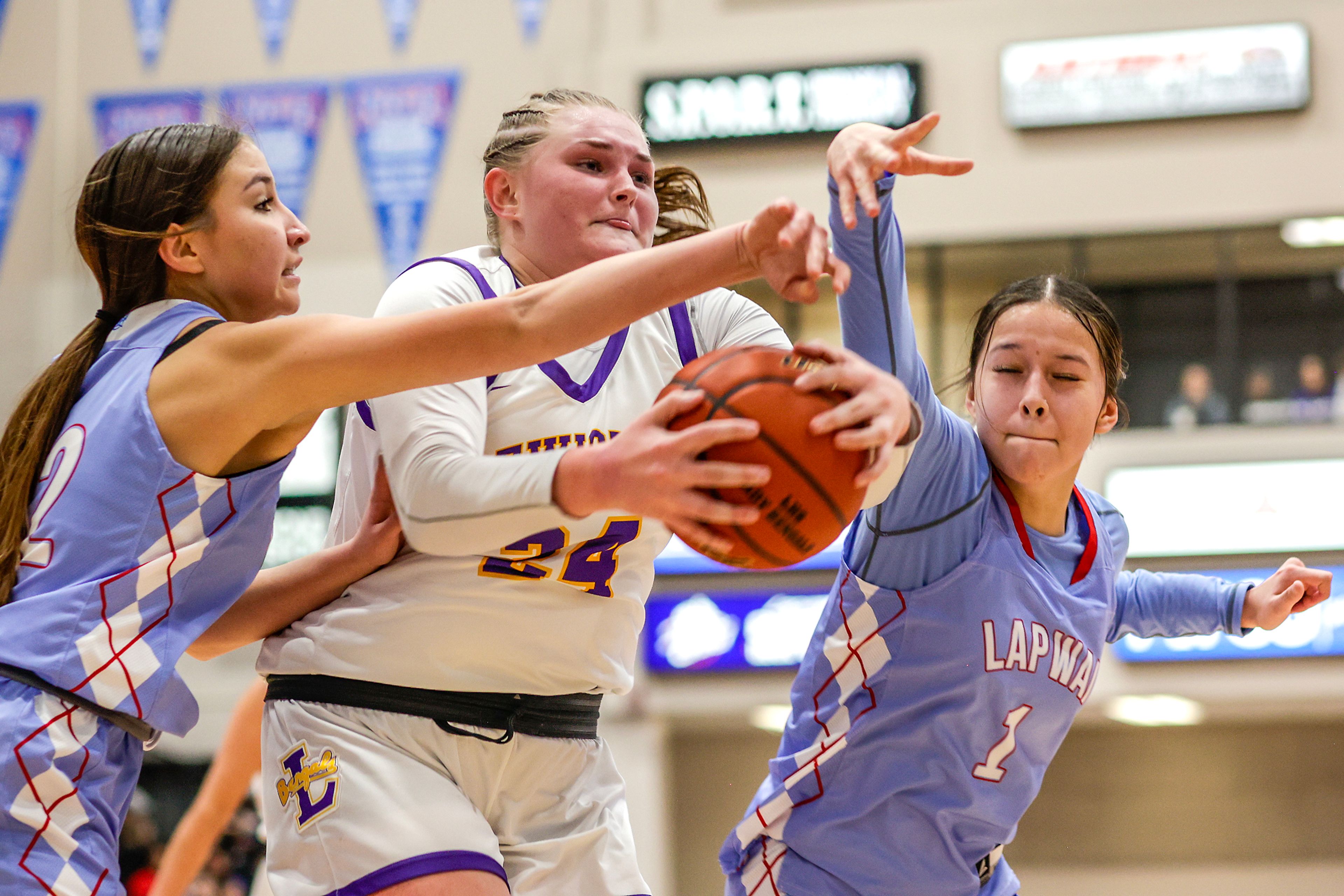 Lewiston post Savannah Burke gets the rebound over Lapwai shooting guard Taya Yearout, left, and shooting guard Jaelyn McCormack-Marks during the Avista Holiday Tournament on Wednesday.