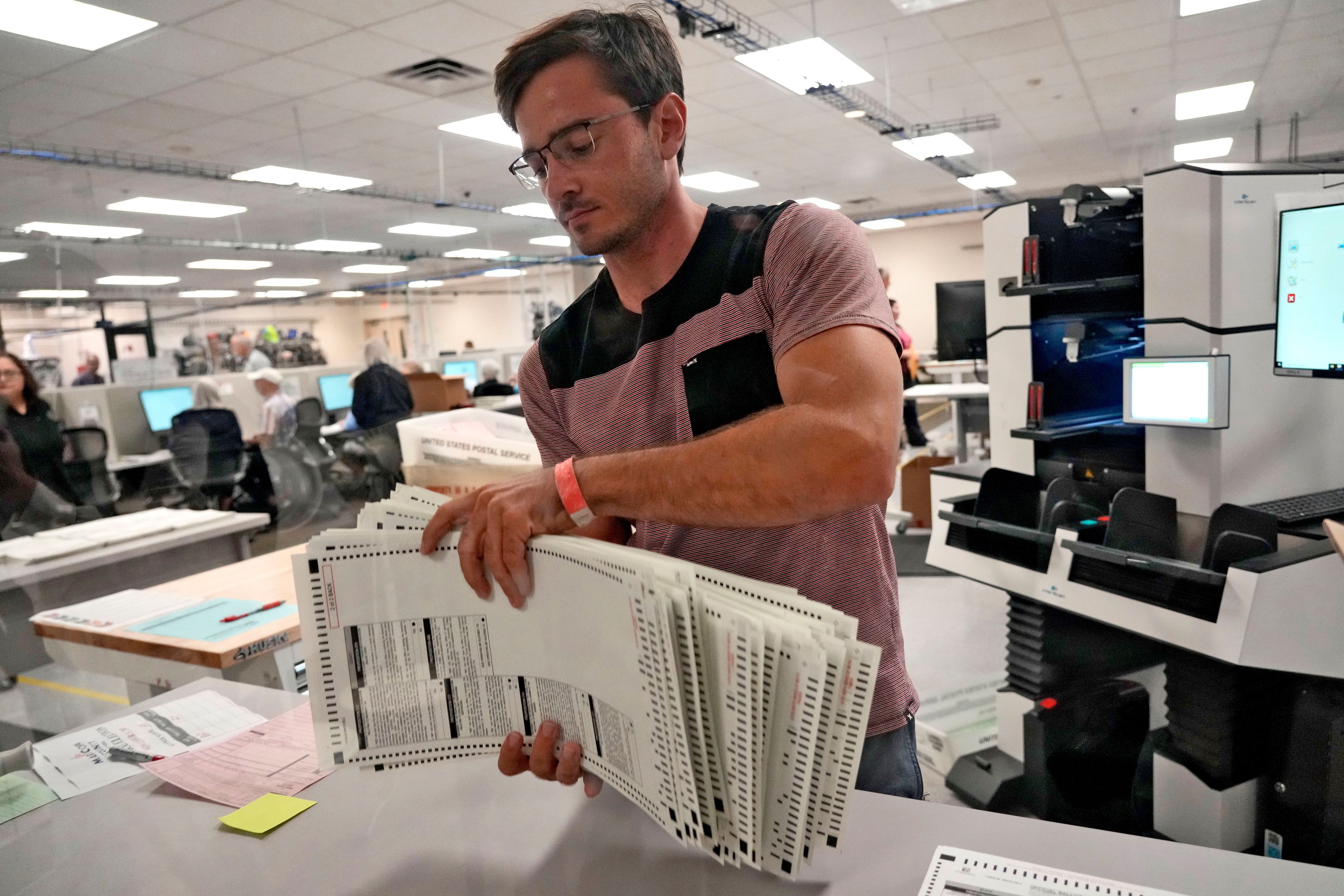 An elections official sorts counted mail-in ballots on the first day of tabulation, Wednesday, Oct. 23, 2024, at the Maricopa County Recorder's Office in Phoenix. (AP Photo/Matt York)