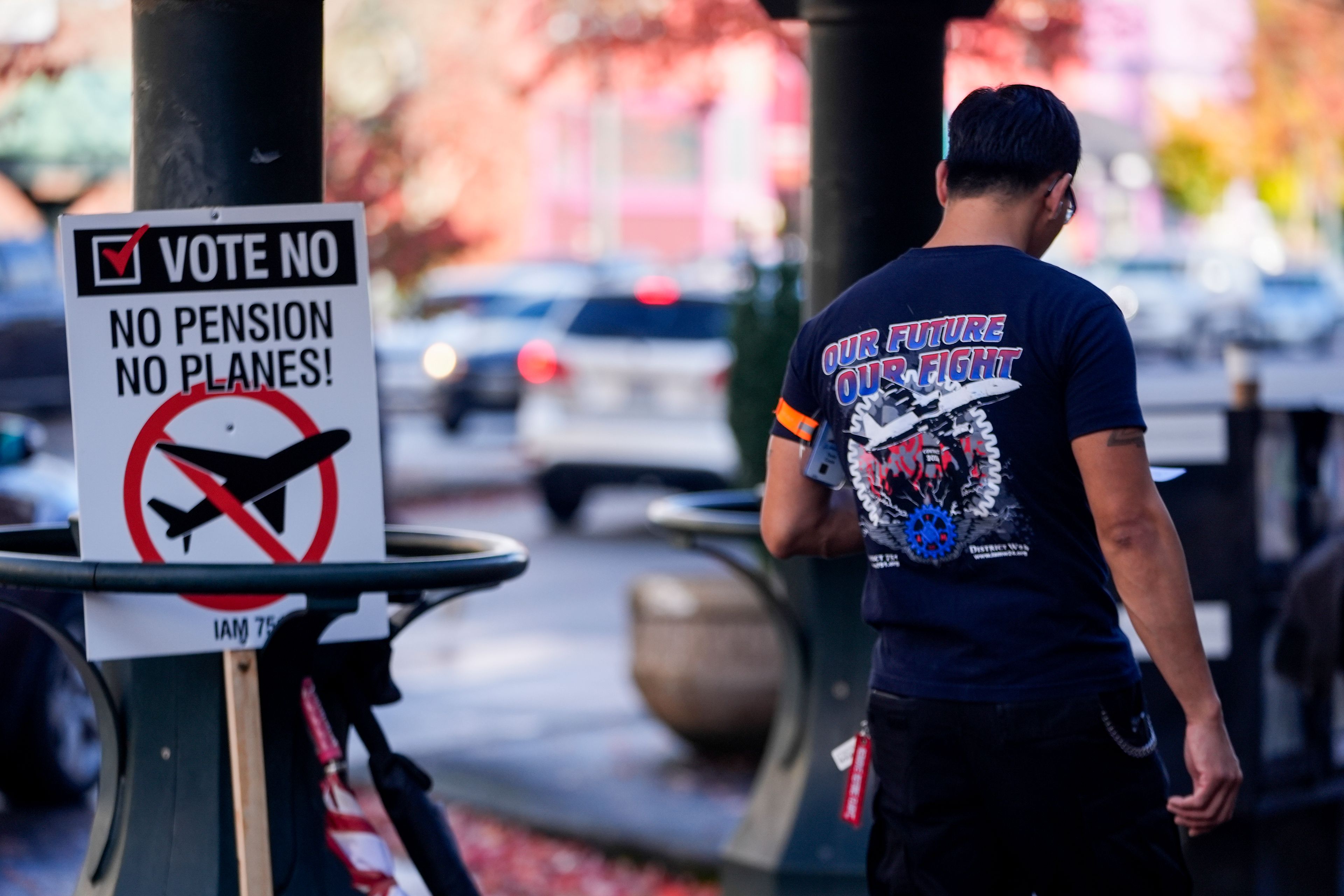 A Boeing employee walks by a picket sign urging people to vote no on a new contract offer from the company, Monday, Nov. 4, 2024, in Everett, Wash. (AP Photo/Lindsey Wasson)