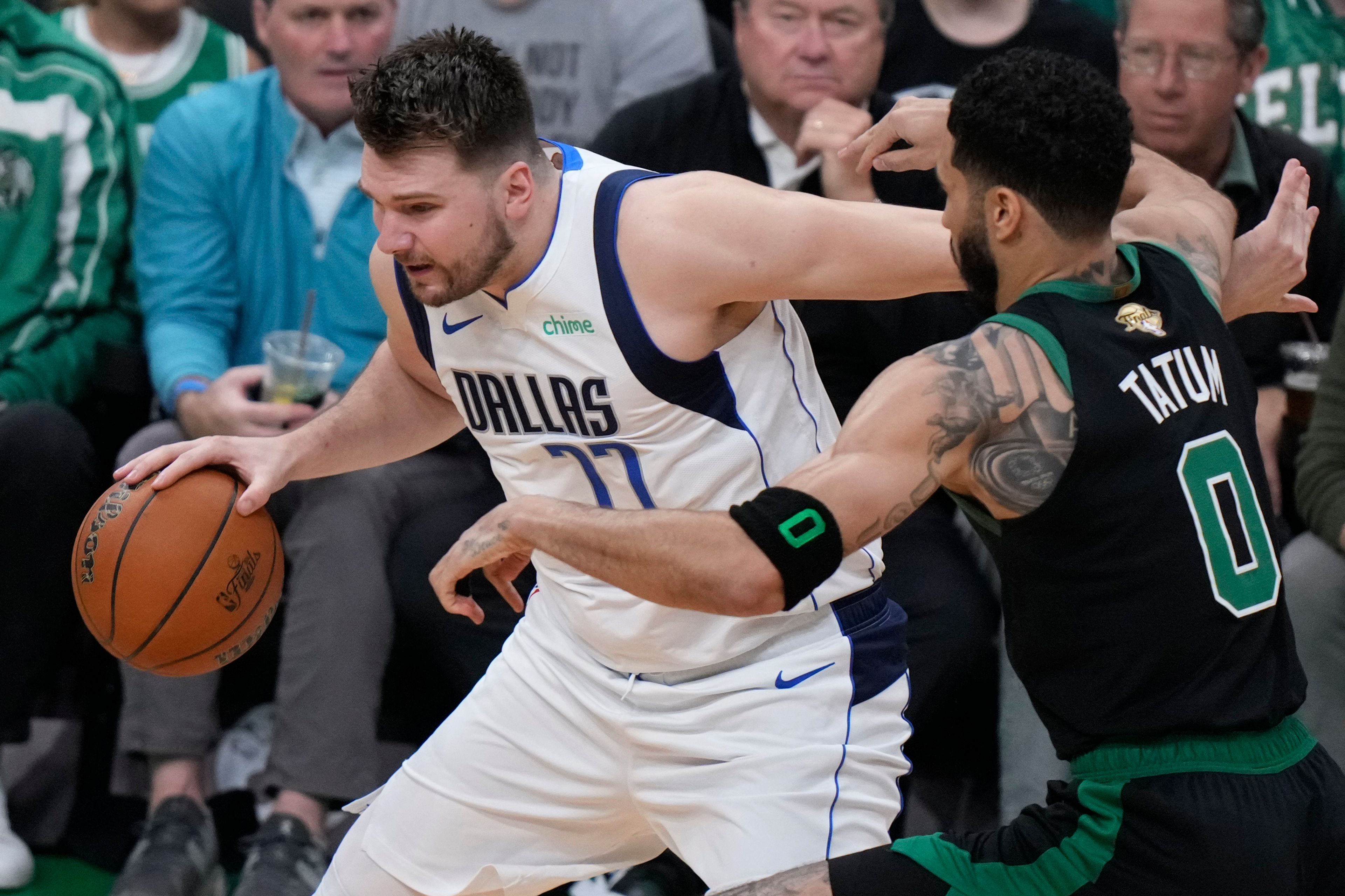 Dallas Mavericks guard Luka Doncic tries to drive past Boston Celtics forward Jayson Tatum (0) during the first half of Game 2 of the NBA Finals basketball series, Sunday, June 9, 2024, in Boston.