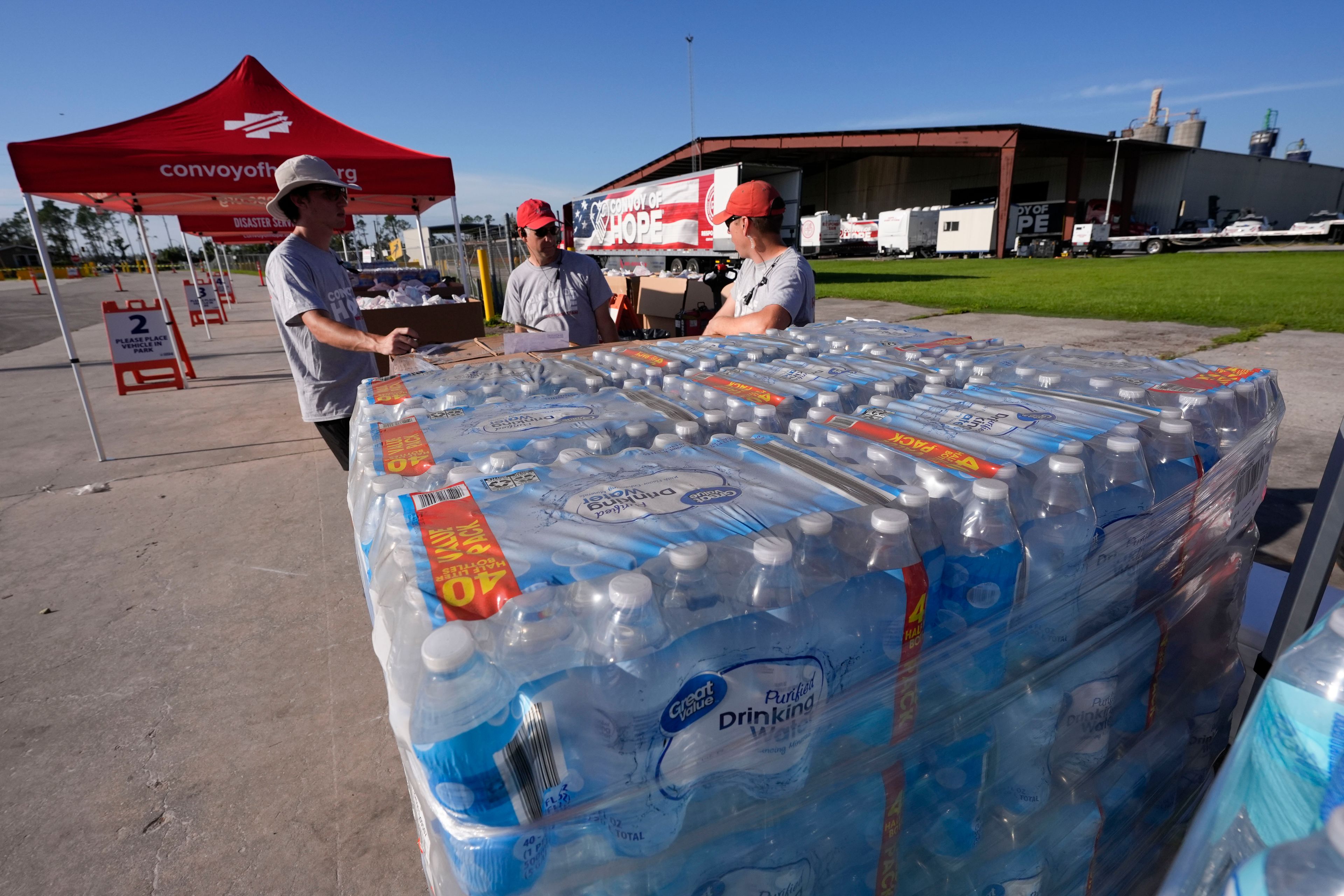 Volunteers from convoyofhope.org wait for fellow volunteers before they open a food distribution operation in the aftermath of Hurricane Helene, in Perry, Fla., Saturday, Sept. 28, 2024. (AP Photo/Gerald Herbert)