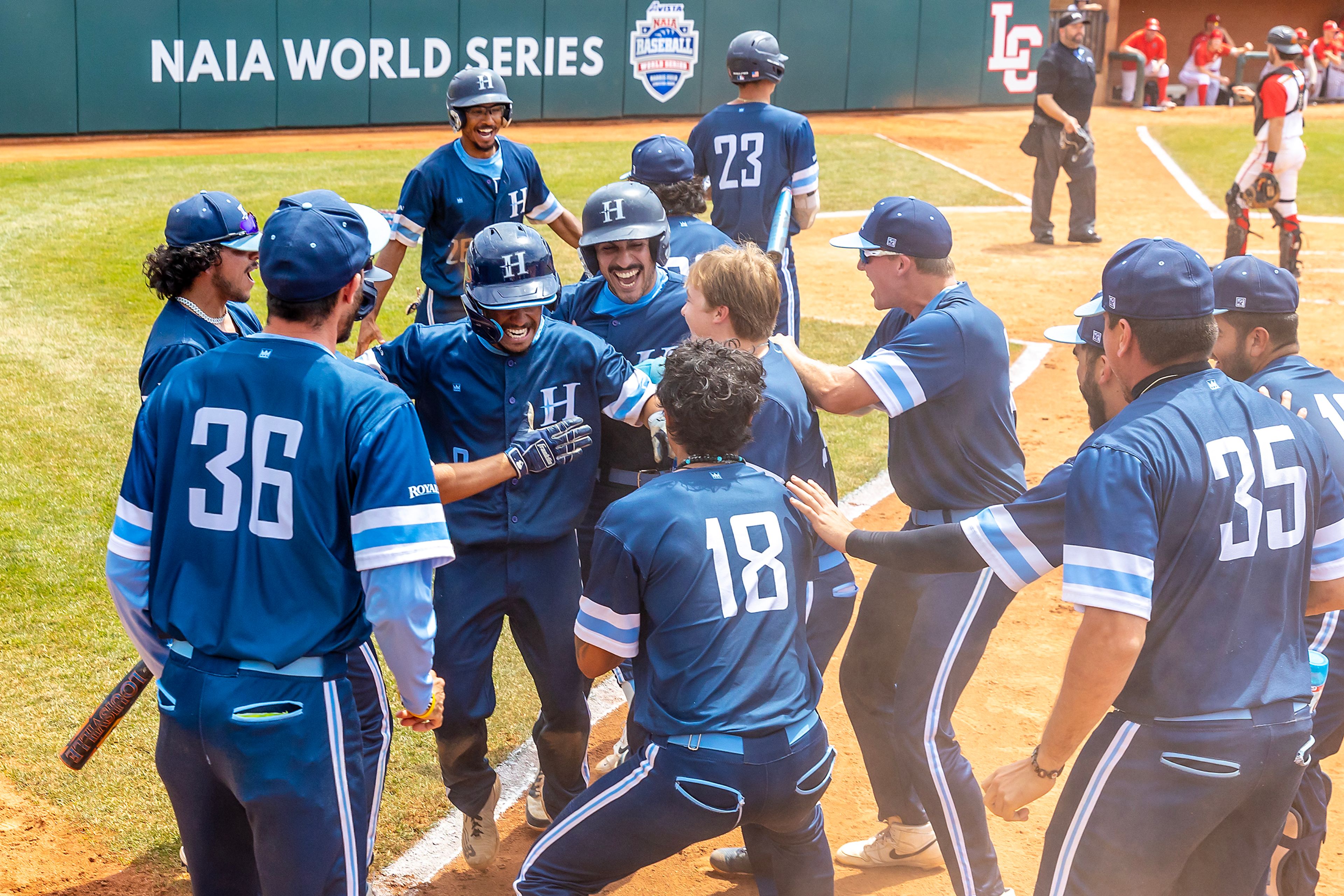 Hope International runners come in after scoring a double run against Arizona Christian in Game 13 of the NAIA World Series on Tuesday at Harris Field in Lewiston.