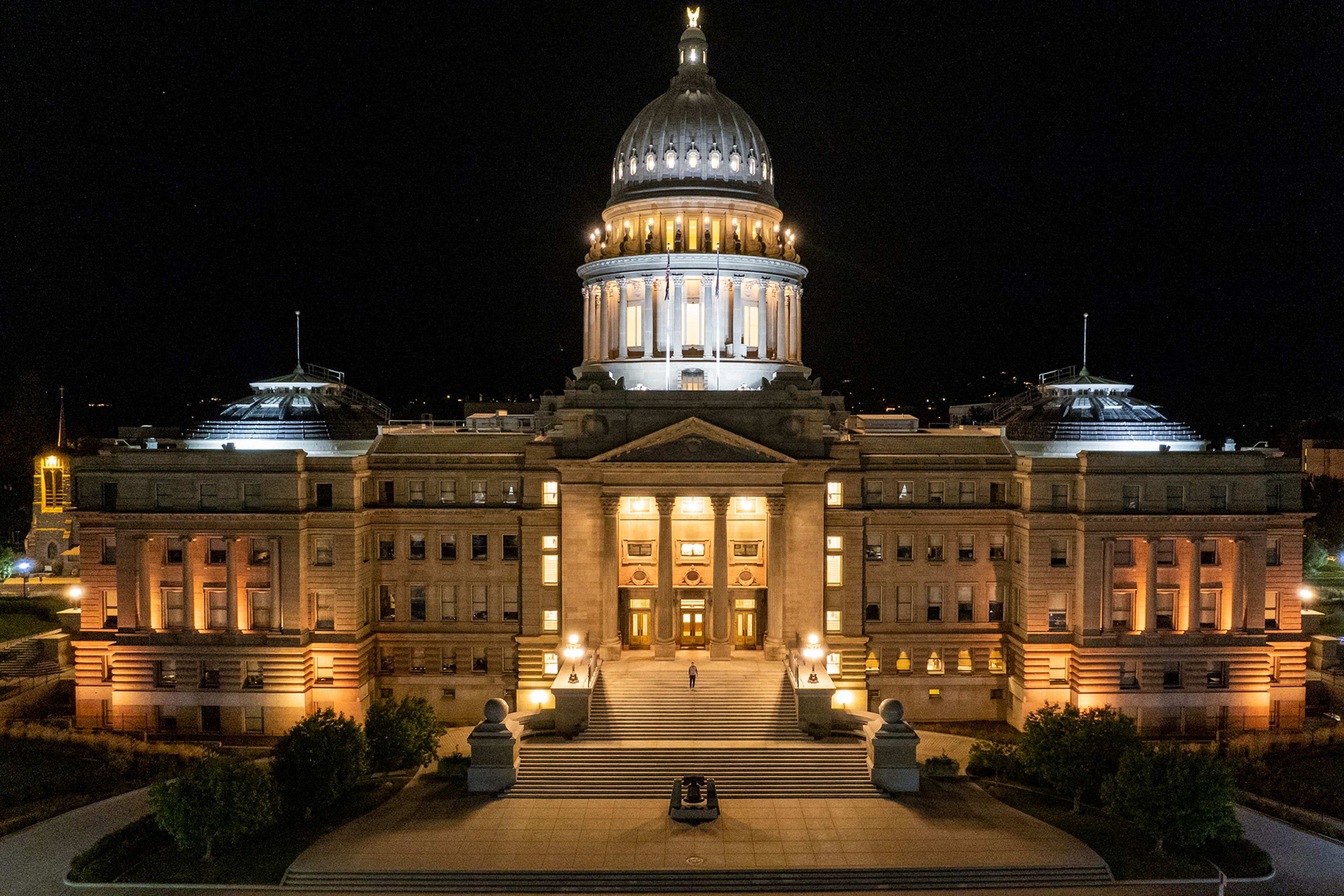 An individual climbs the steps of the Idaho State Capitol building in the fall in Boise.