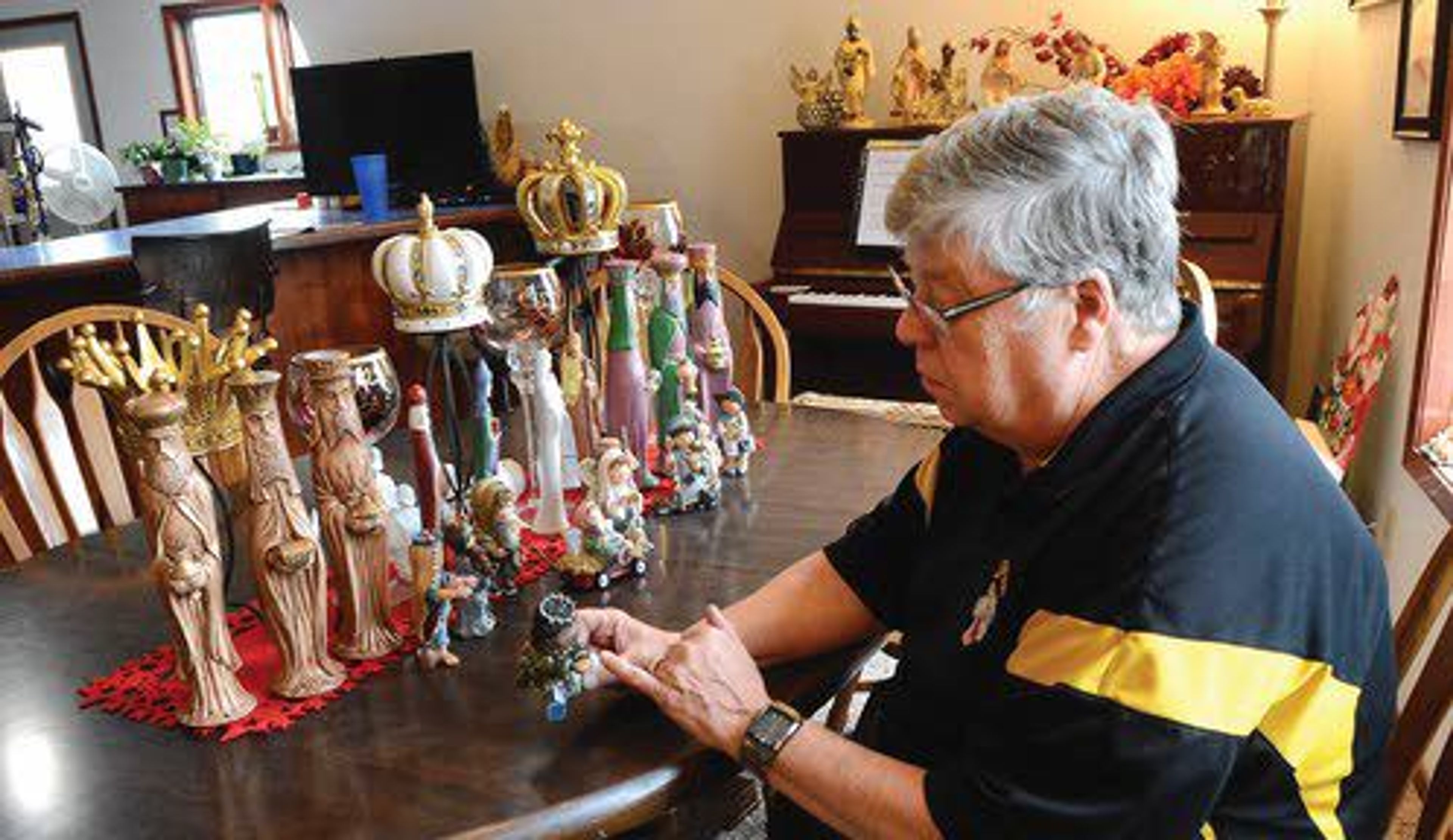 Tribune/Steve HanksDennis Ohrtman of Lewiston sits at his dining room table and describes the intricate design of a Nativity scene.