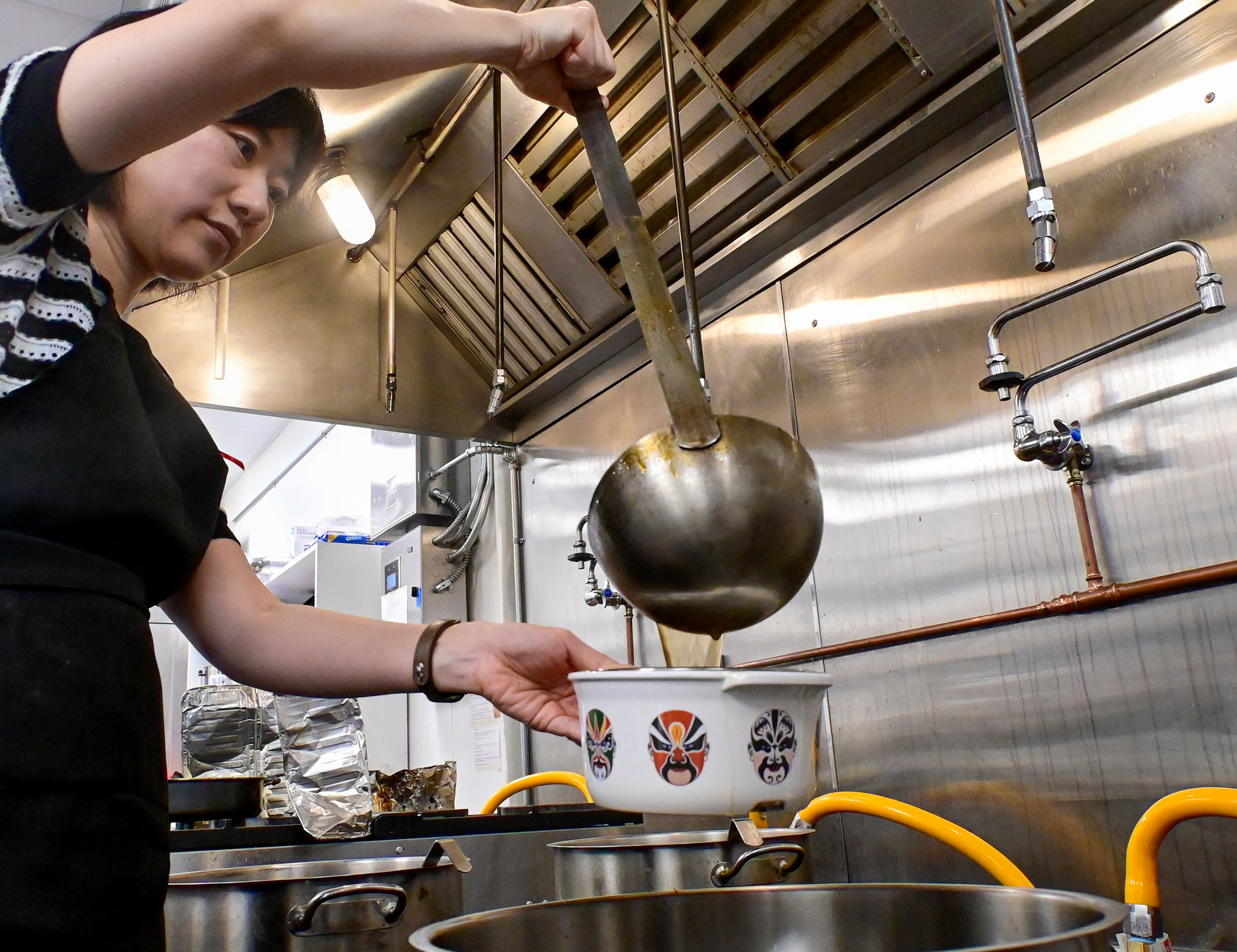 Everhot Hot Pot owner Jessica Liu pours broth into an individual-sized bowl at the restaurant on Wednesday.