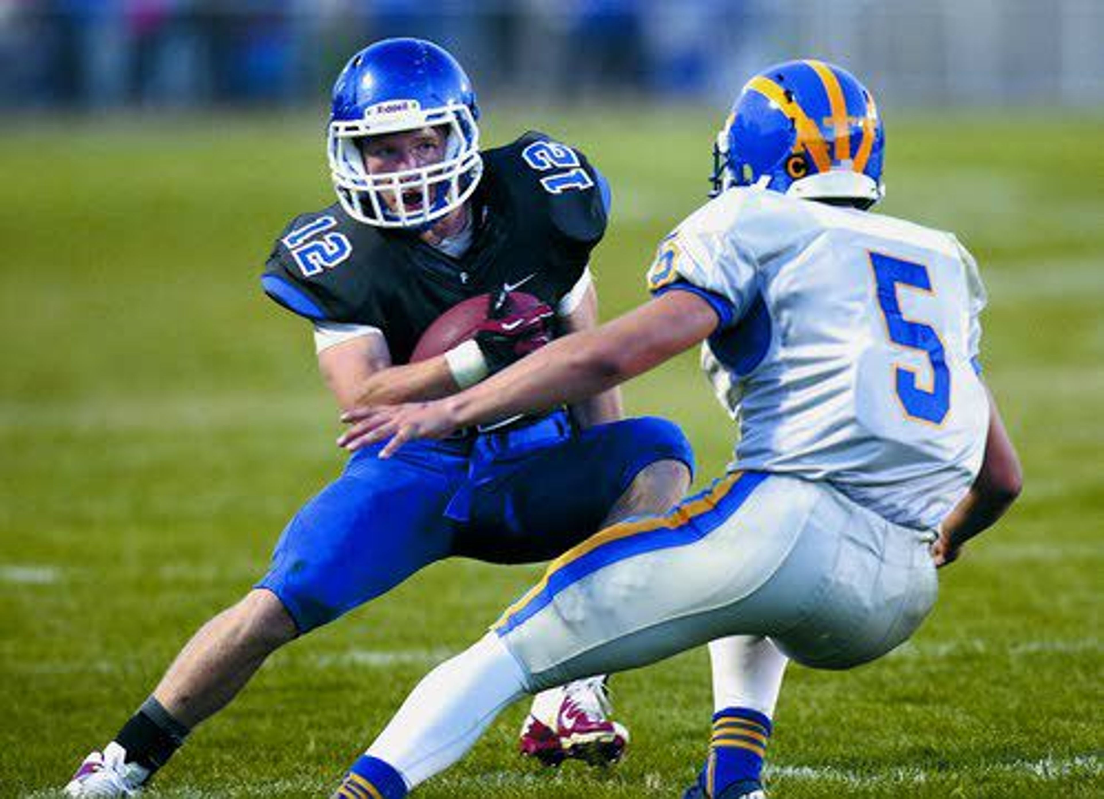 Pullman running back Jed Byers (12) tries a fake move against Fife’s Jackson Cooley Friday night during the Hounds’ season opener.