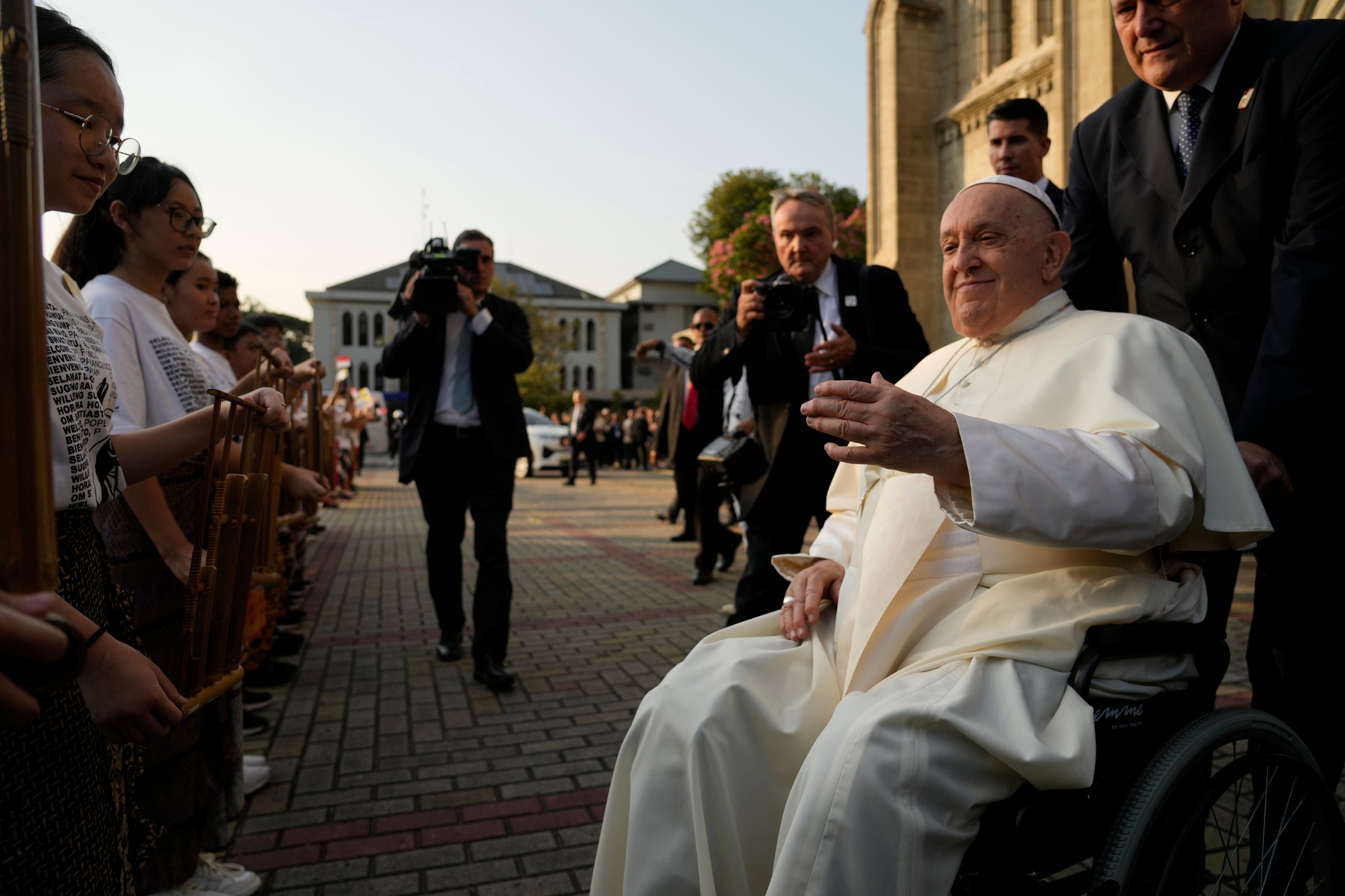 Pope Francis is greeted by faithful as he arrives at the Cathedral of Our Lady of the Assumption in Jakarta, Wednesday, Sept. 4, 2024. Pope Francis urged Indonesia to live up to its promise of "harmony in diversity" and fight religious intolerance on Wednesday, as he set a rigorous pace for an 11-day, four-nation trip through tropical Southeast Asia and Oceania that will test his stamina and health.