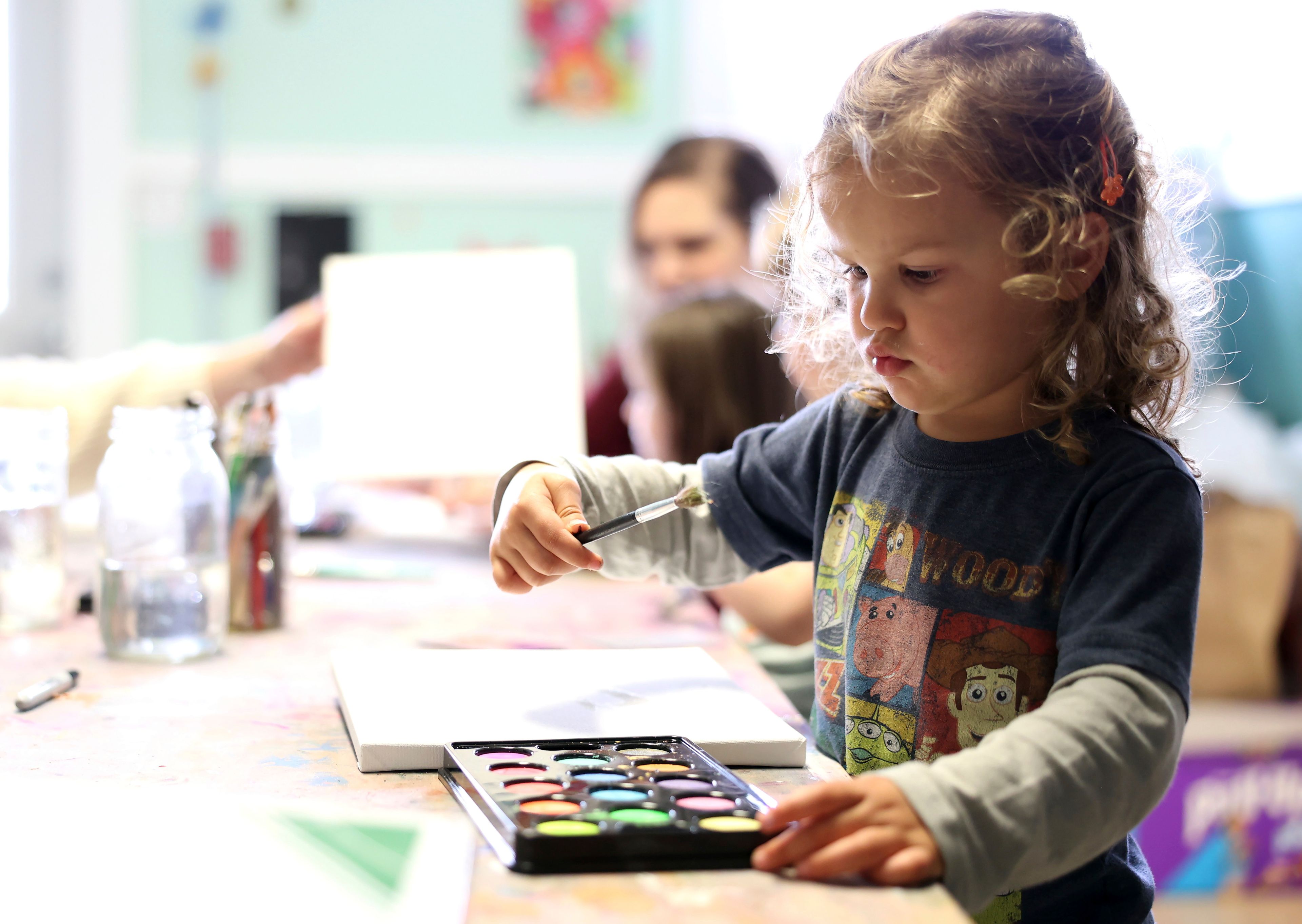 Quinncey Hollowell, 3, paints at Bumble Art Studio day care center in Astoria, Ore., Friday, Sept. 2, 2022. From Oregon to New York, demand for child care far exceeds supply. Families are growing increasingly desperate as providers deal with staffing shortages exacerbated by the coronavirus pandemic as well as historically low pay worsened by inflation. (AP Photo/Craig Mitchelldyer)