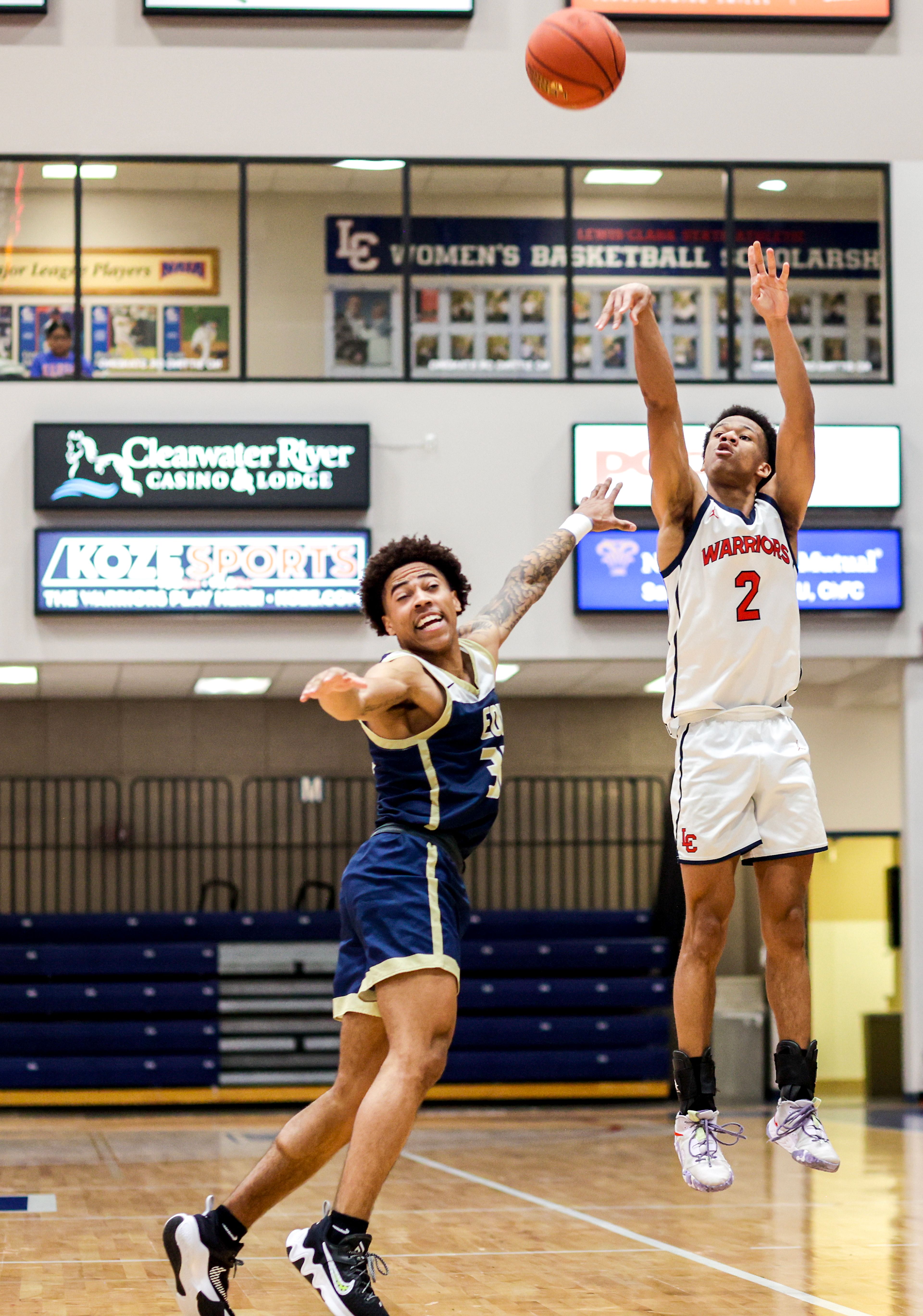 Lewis-Clark State guard Davian Brown, right, shoots a 3-pointer as Eastern Oregon guard Andre Huddleston defends during a Cascade Conference game Friday at Lewis-Clark State College.