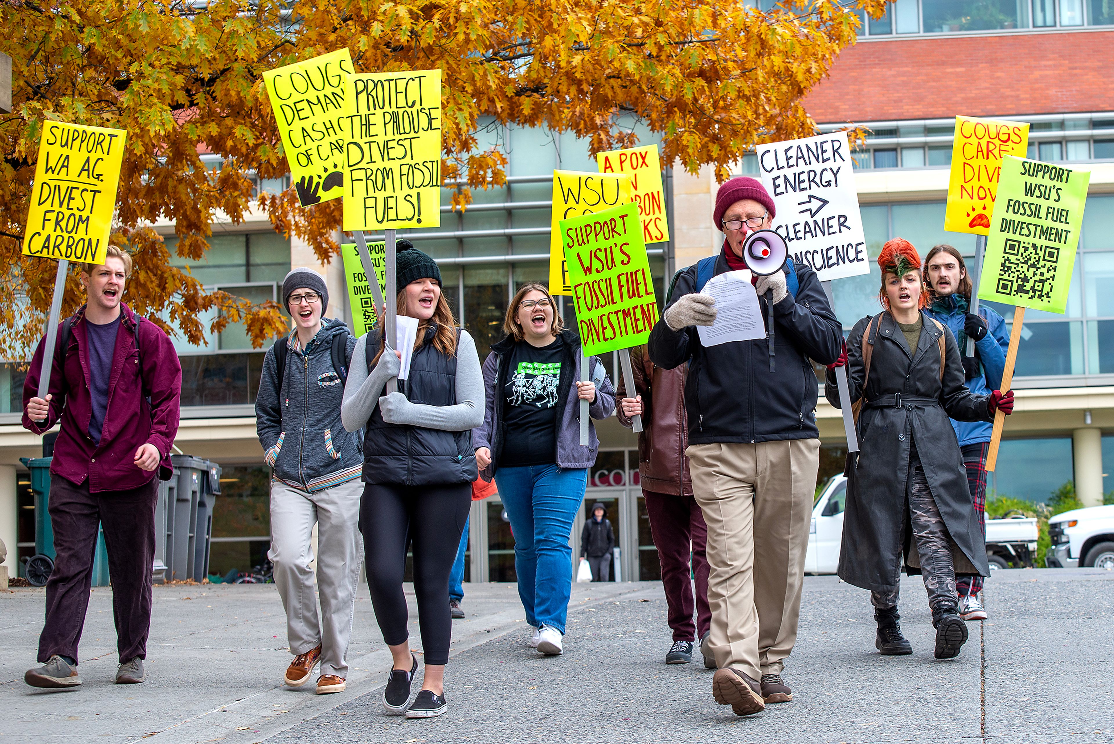 Bill Engels, member of Washington State University Graduate Writing Center and Fossil Free WSU, leads the group through campus Wednesday in a protest calling on the college to divest from fossil fuels in Pullman.