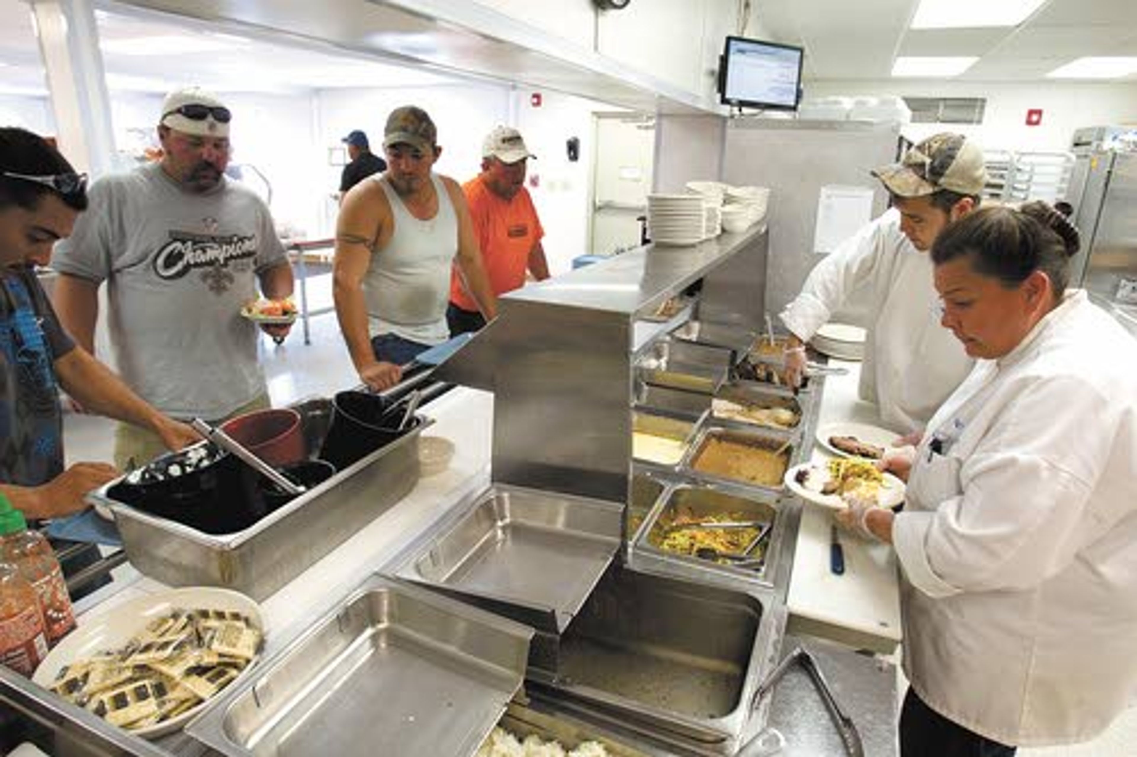 Workers line up for dinner at a temporary housing unit outside
of Williston, N.D.