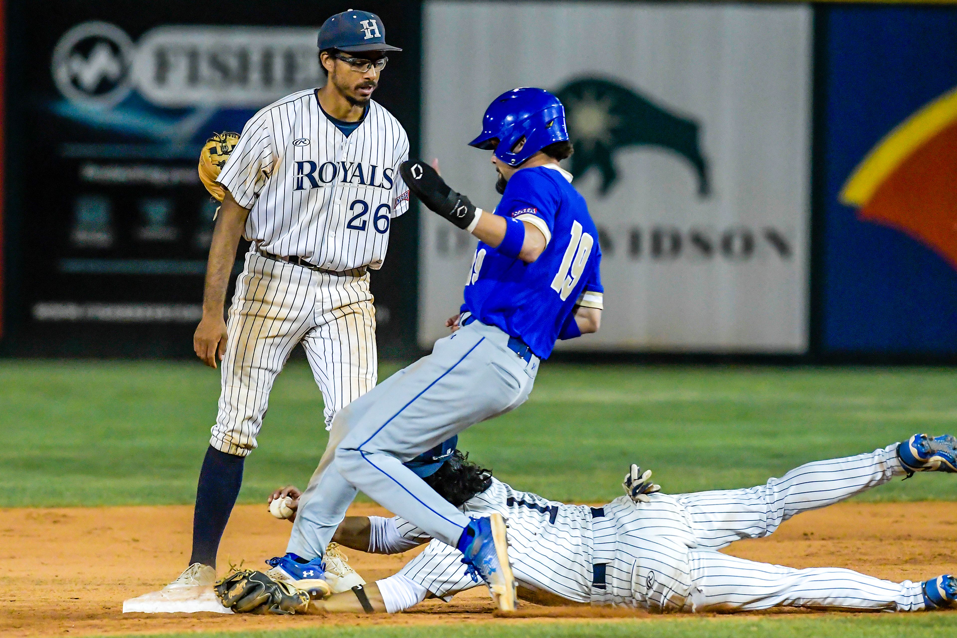 Hope International shortstop David Rivera has his wrist stepped on by Tennessee Wesleyan’s Kruise Newman as he runs to second base in Game 19 of the NAIA World Series at Harris Field Friday in Lewiston.