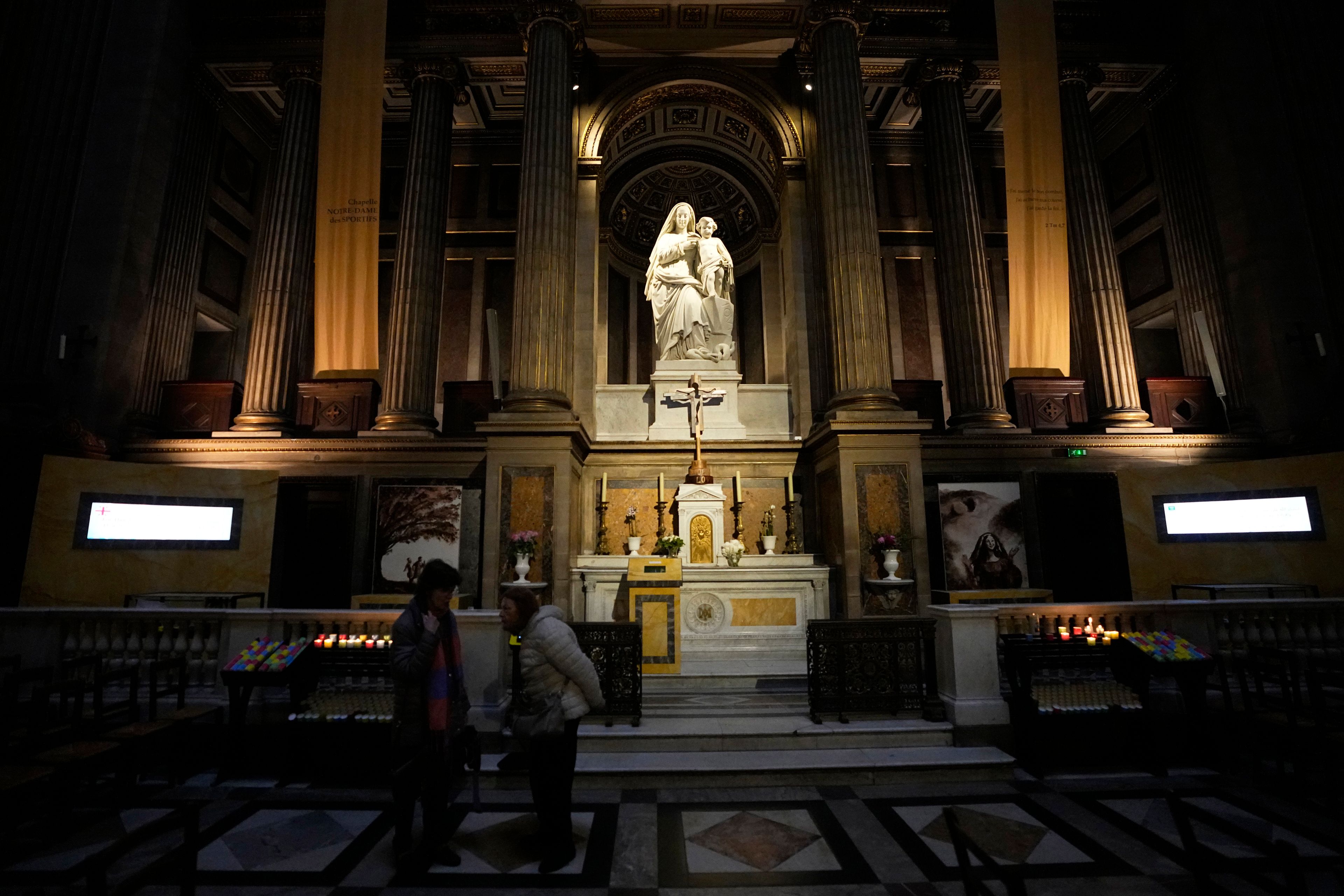 Women stand in front of the "Our Lady of Athletes" chapel inside the Madeleine church, Thursday, May 30, 2024 in Paris. France's Catholic Bishops Conference has launched a nationwide "Holy Games" initiative. Since last September, it has set up the "Our Lady of Athletes" chapel in an iconic downtown Paris church, La Madeleine.