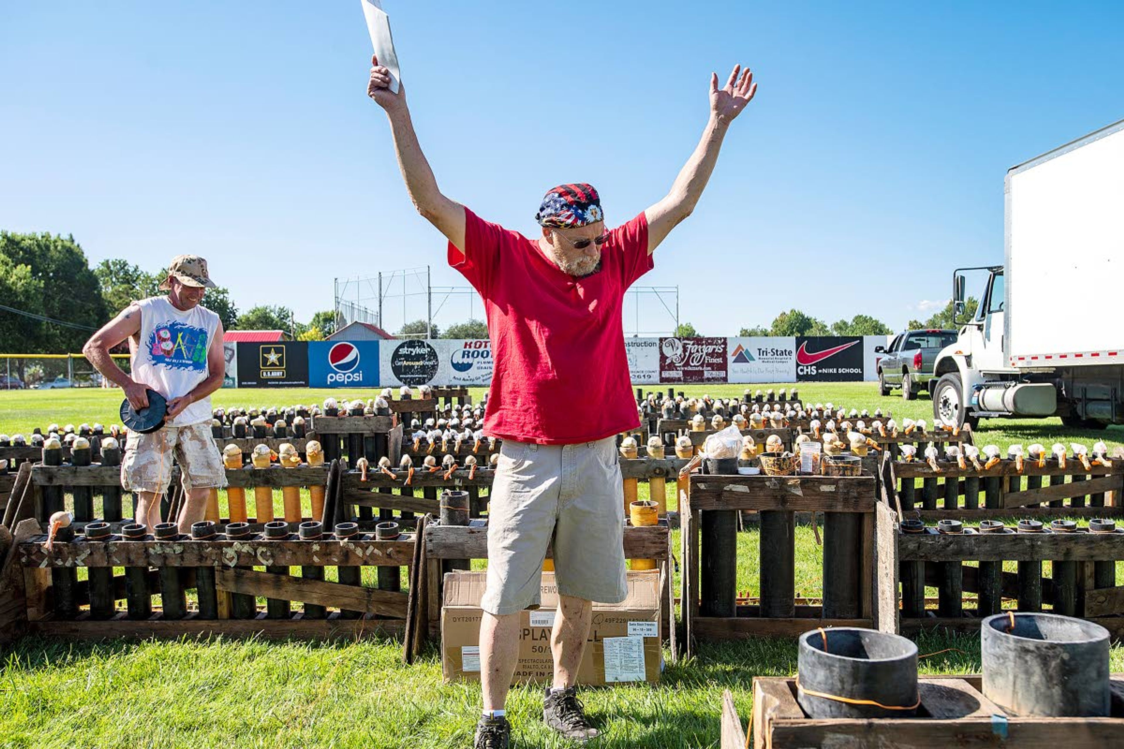 Pyro technician Jeff Casali jokingly raises his arms in frustration as he and Mike McCann, of Bovill, set the fuses for hundreds of fireworks for the Fourth of July fireworks show at Adams Field in Clarkston.