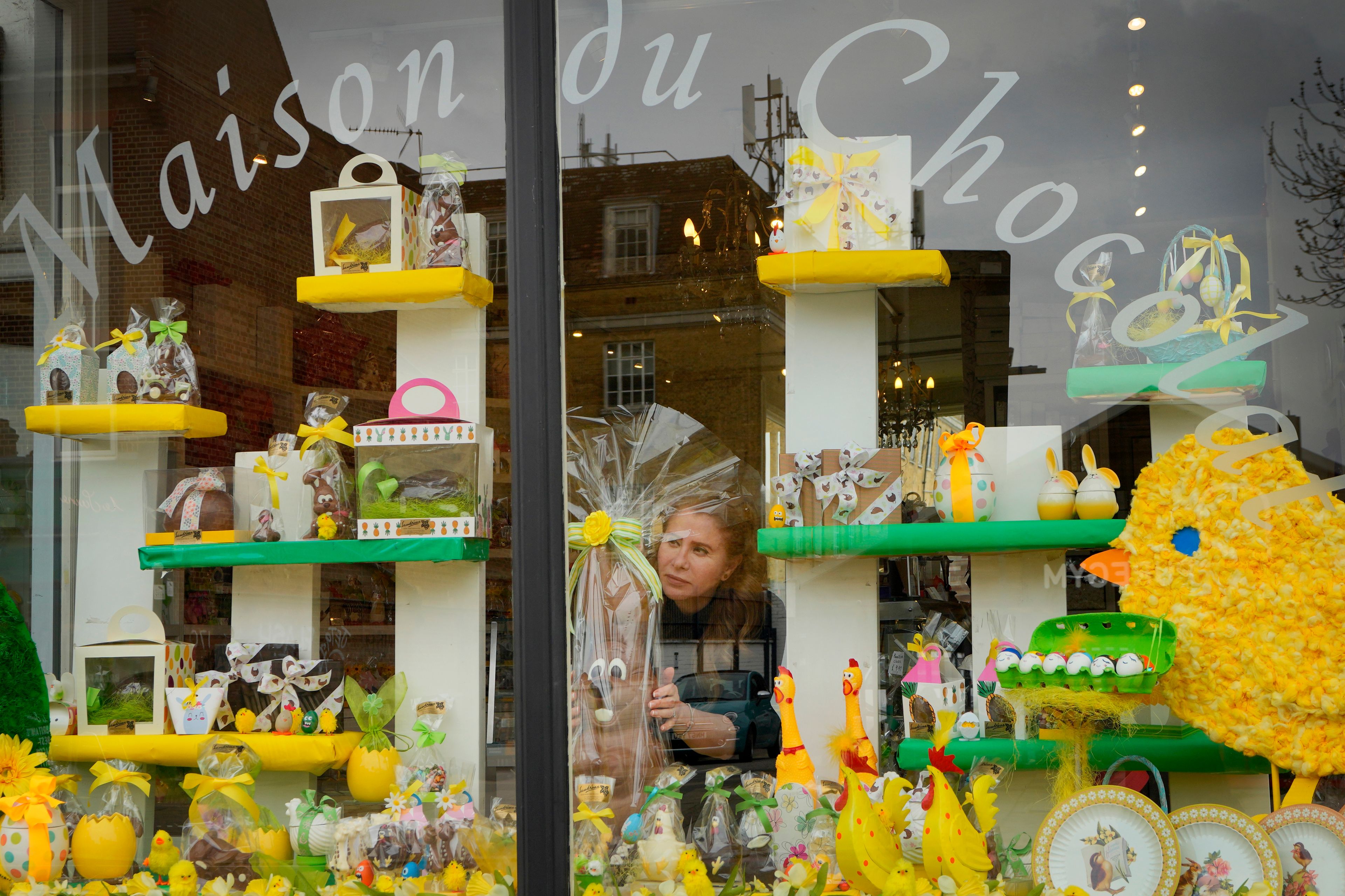 Niaz Mardan places a large luxury handmade Belgian chocolate rabbit in the window display of Sandrine a chocolate shop in south west London, Thursday, March 21, 2024. Niaz Mardan, is suffering due to high cocoa prices, she's making no profits and fears she will have to close the shop that's been around for 25 years (she's the third owner and took over in 2019). (AP Photo/Kirsty Wigglesworth)