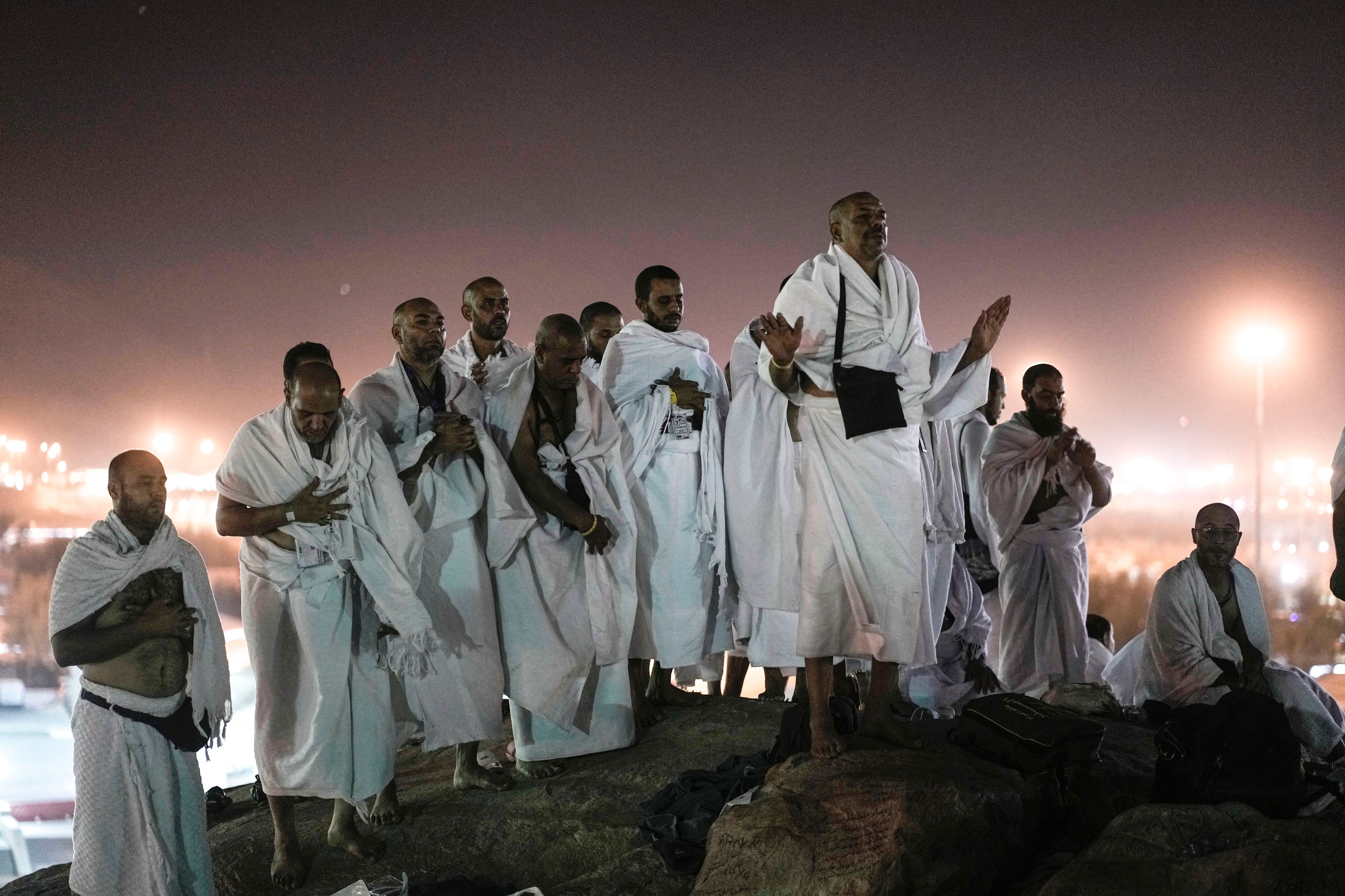 FILE - Muslim pilgrims pray on the rocky hill known as the Mountain of Mercy, on the Plain of Arafat, during the annual Hajj pilgrimage, near the holy city of Mecca, Saudi Arabia, on June 27, 2023. A spiritual highlight of Hajj for many is the standing on the plain of Arafat, where pilgrims praise God, plead for his forgiveness and make supplications.