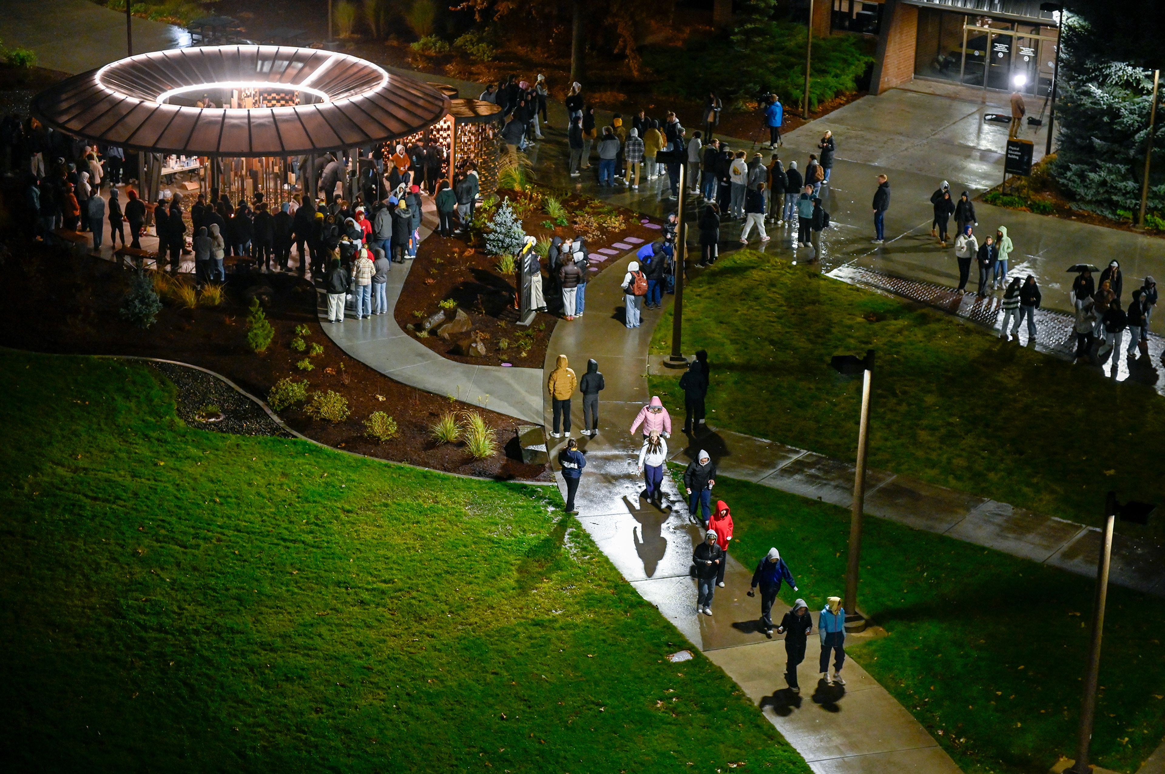 Those gathered for a vigil marking two years since the murder of four University of Idaho students begin to leave the Vandal Healing Garden and Memorial after spending time in the space holding candles and writing notes Wednesday in Moscow.