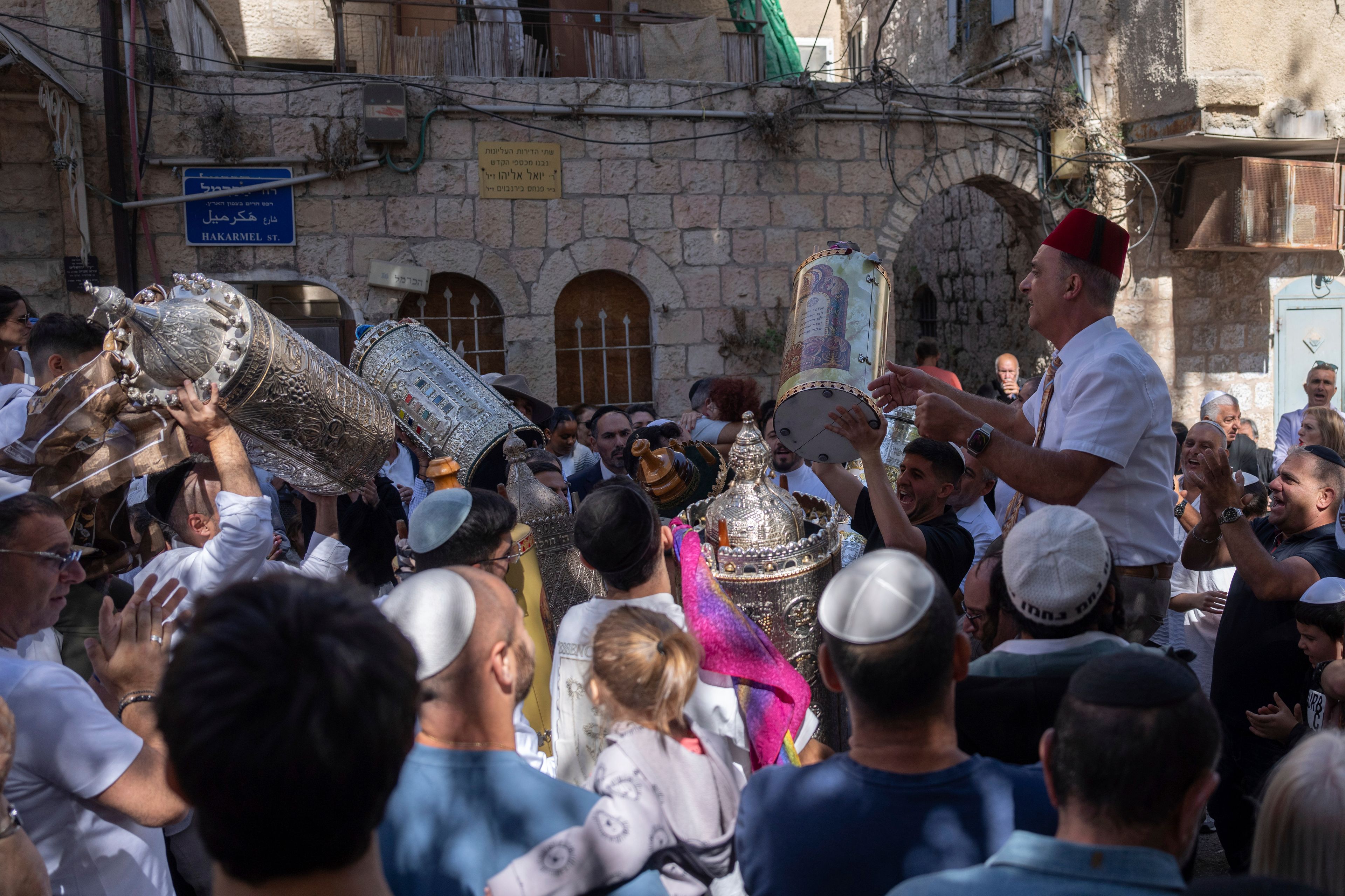 Jewish revelers dance in a circle during the holiday of Simchat Torah, on the first anniversary on the Jewish calendar of the day Hamas militants attacked Israel, in Jerusalem, Thursday Oct. 24, 2024. (AP Photo/Ohad Zwigenberg)