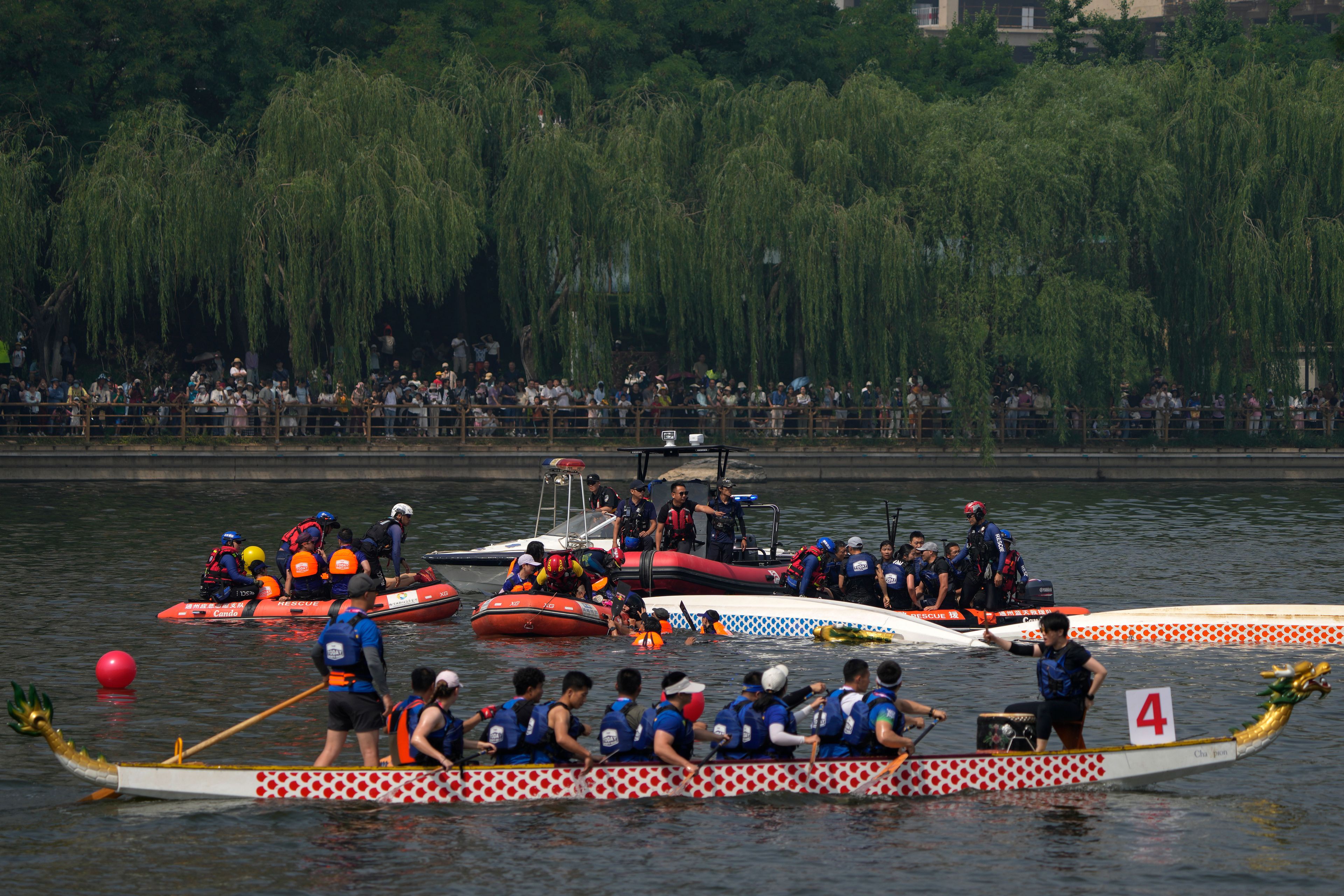 Rescuers help the dragon boat racers following a crash during the Dragon Boat festival at a canal in Tongzhou, on the outskirts of Beijing, Monday, June 10, 2024. The Duanwu festival, also known as the Dragon Boat festival, falls on the fifth day of the fifth month of the Chinese lunar calendar and is marked by celebrations like eating rice dumplings and racing dragon boats.