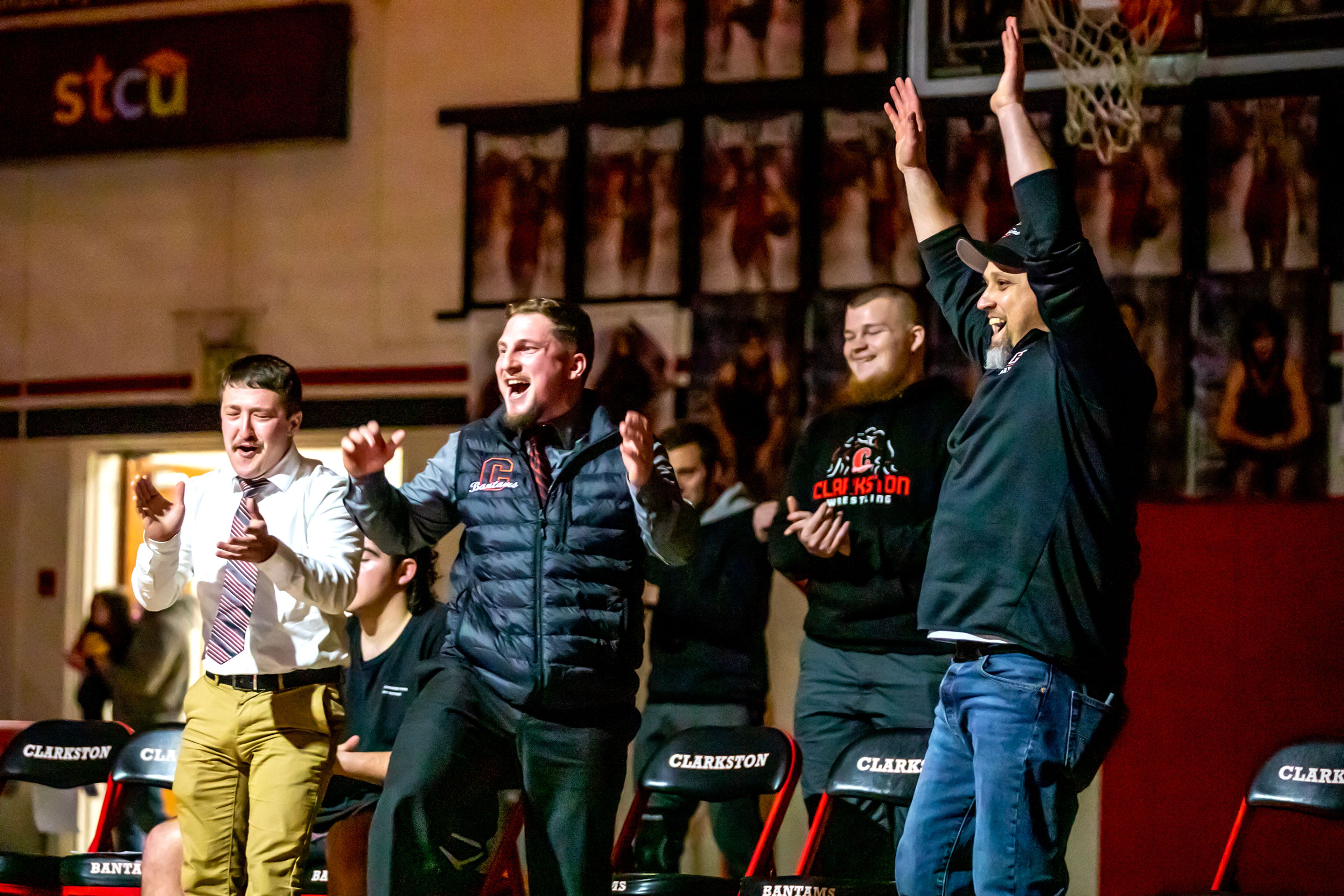 Clarkston coaches celebrate Colby Valdez’s victory over Brodey Mogan in the 120 pound weight class match during a wrestling duel Wednesday at Clarkston.