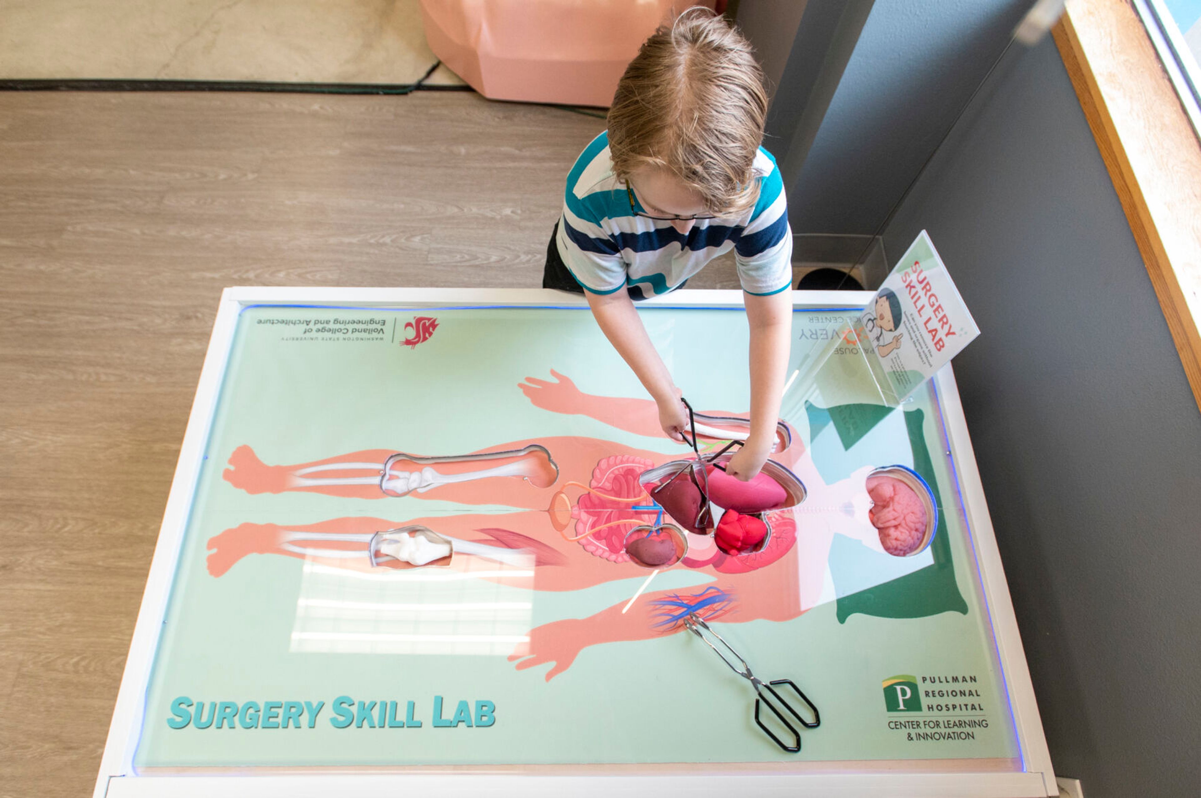 Jason, a fourth grader at Palouse Prairie Charter School, carefully removes organs from a life-sized version of the game Operation at the Palouse Discovery Science Center in Pullman on Thursday.