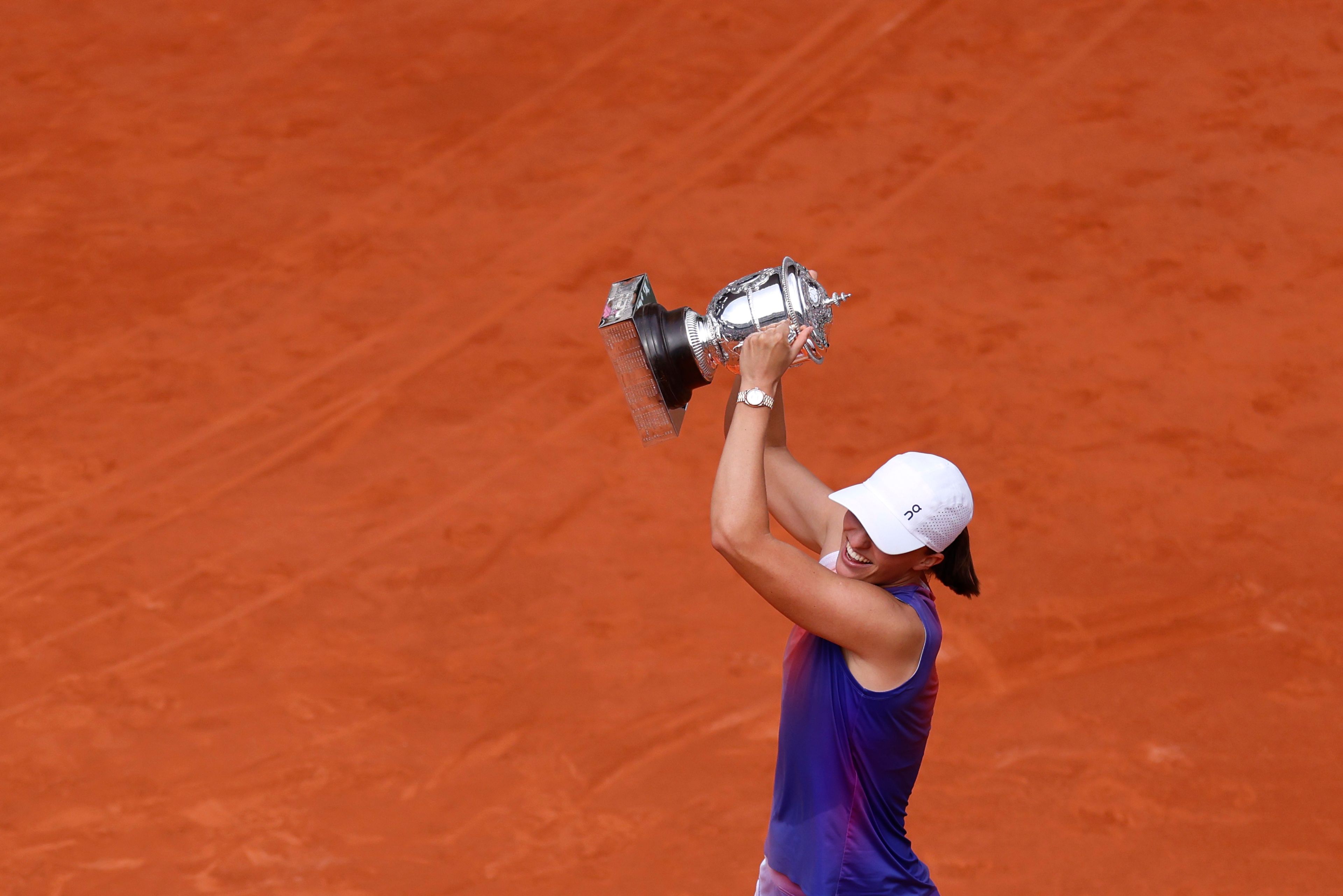 Poland's Iga Swiatek celebrates with the trophy as she won the women's final of the French Open tennis tournament against Italy's Jasmine Paolini at the Roland Garros stadium in Paris, France, Saturday, June 8, 2024.