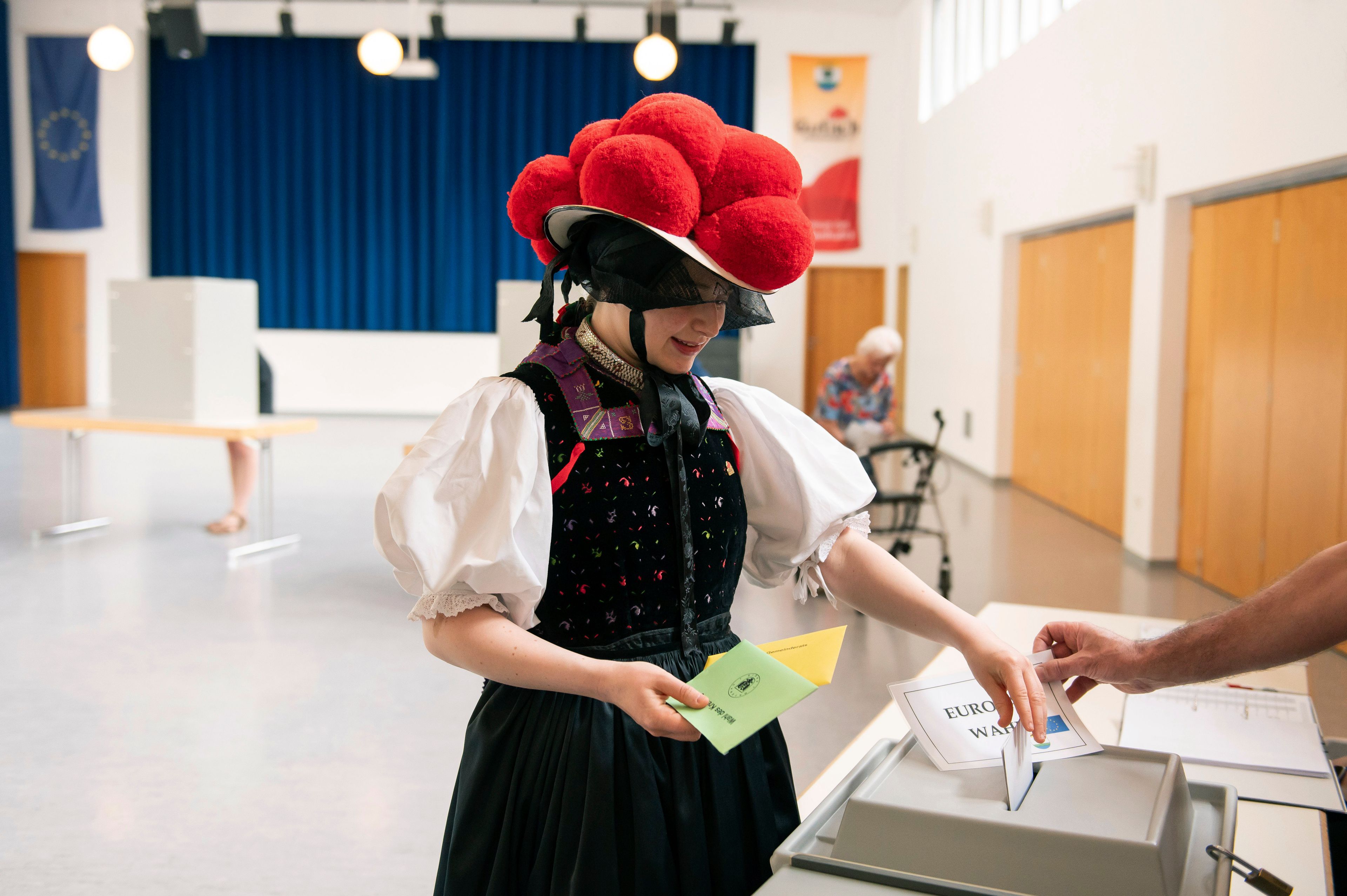 Katharina Moser, dressed in traditional Black Forest attire. with red Bollenhut hat, casts her ballot for the European Parliament elections at the polling stationm in Gutach im Breisgau, Germany, Sunday, June 9, 2024.