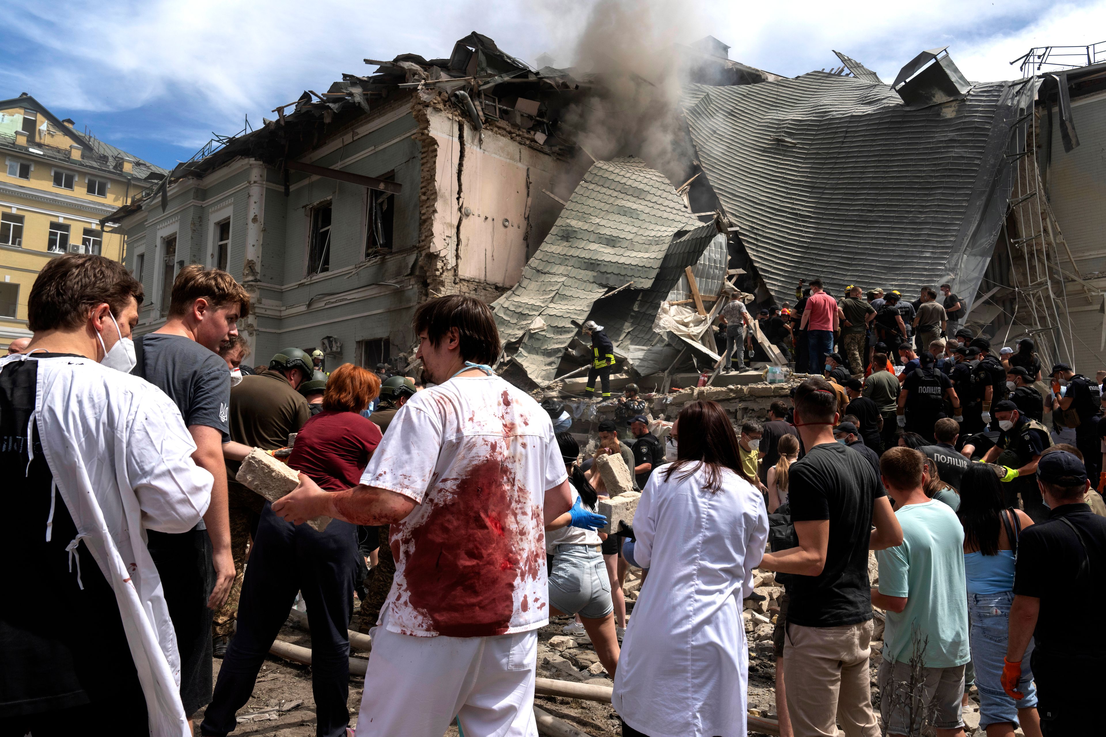 Rescuers, volunteers and medical workers, some in bloodied uniforms clean up the rubble and search victims after Russian missile hit the country's main children hospital Okhmadit, in Kyiv, Ukraine, Monday, July 8, 2024. A major Russian missile attack across Ukraine killed at least 20 people and injured more than 50 on Monday, officials said, with one missile striking a large childrenâ€™s hospital in the capital, Kyiv, where emergency crews searched rubble for casualties. (AP Photo/Efrem Lukatsky)