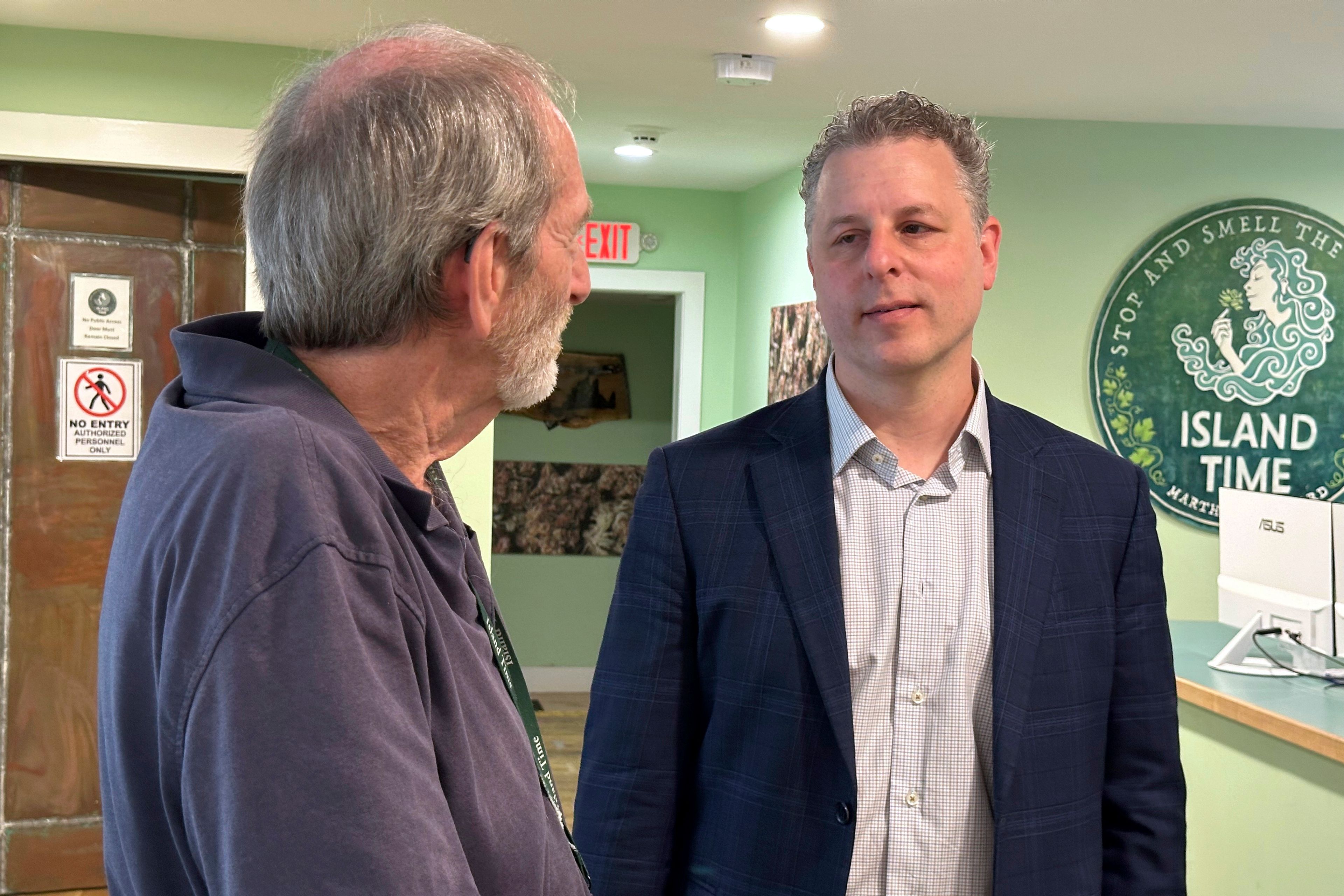 Geoff Rose, left, owner of the Island Time cannabis dispensary, talks with lawyer Adam Fine in Rose's store on June 3, 2024, in Vineyard Haven, Mass.