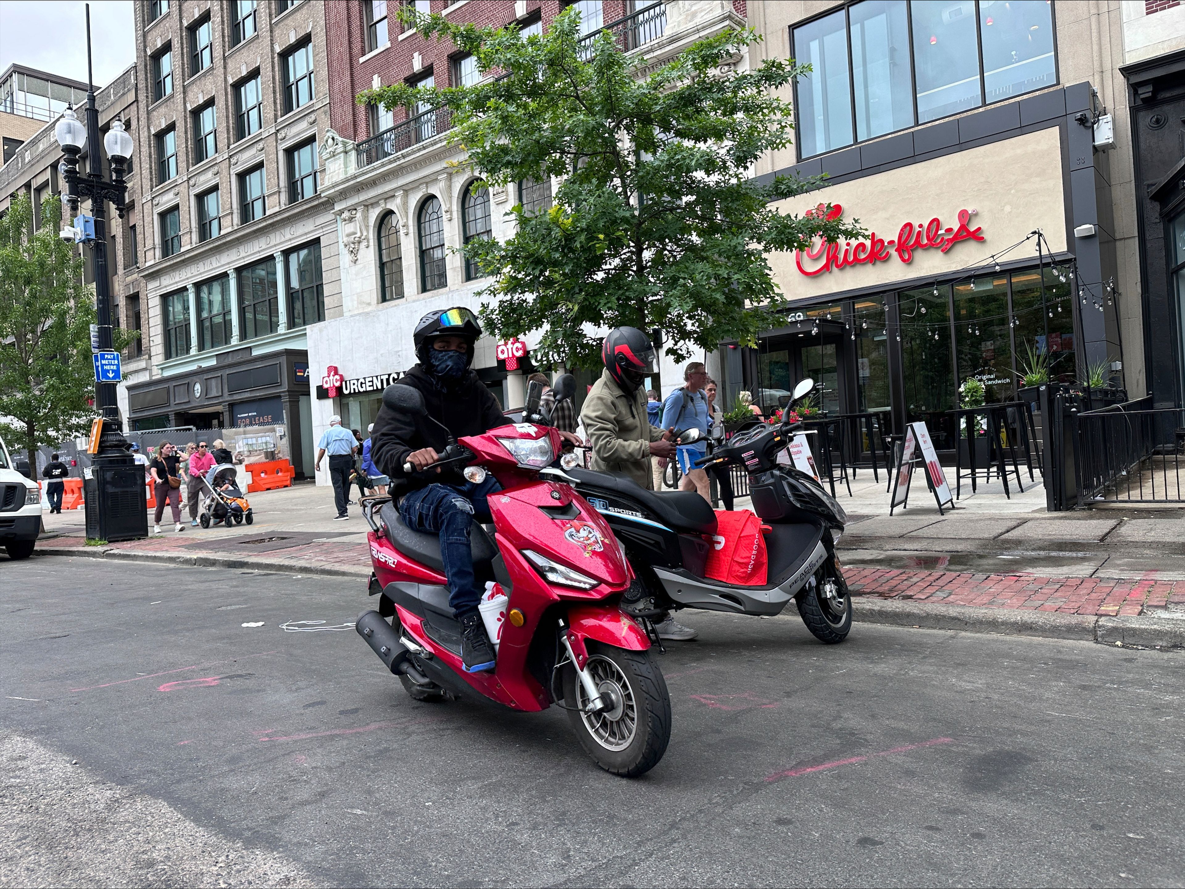 Delivery scooters are parked as drivers wait to pick up food for delivery, Thursday, June 6, 2024, in Boston. Boston and New York are cracking down on unlawful drivers, whom they say are ignoring traffic laws and making city streets more dangerous.