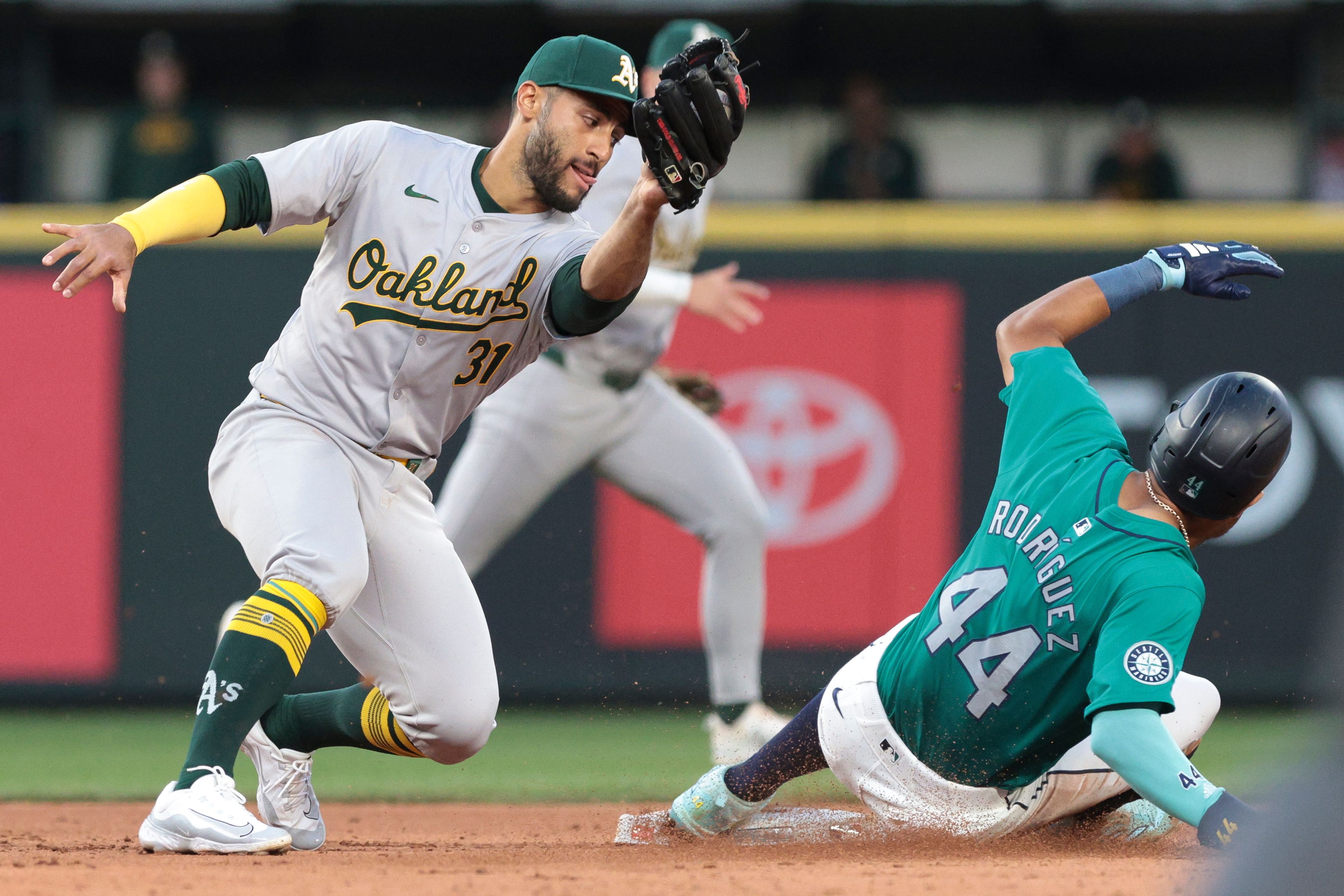 Athletics second baseman Abraham Toro (31) goes to tag the Mariners' Julio Rodríguez on a steal attempt during the sixth inning of a game Saturday, May 11, 2024, in Seattle.