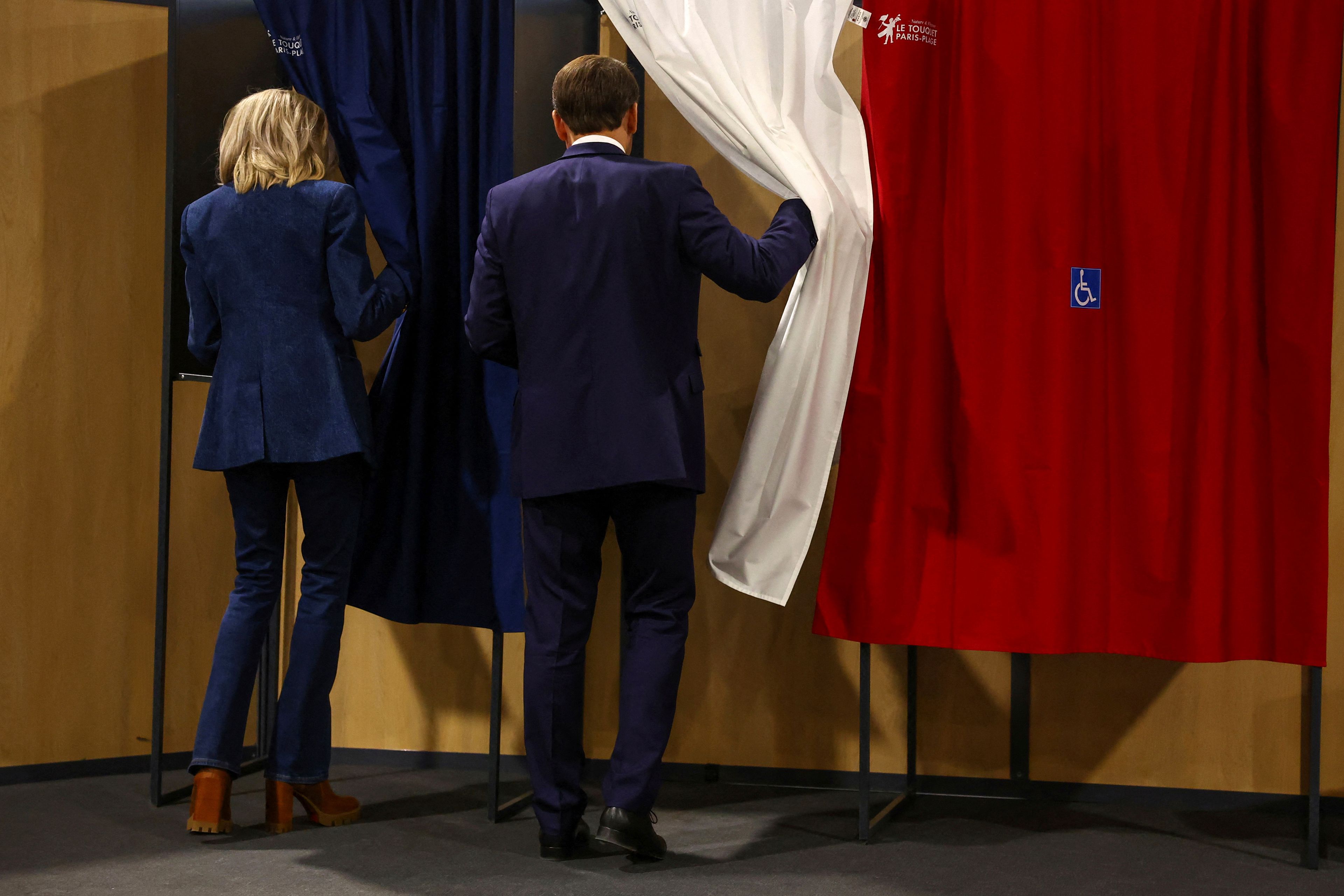 French President Emmanuel Macron and his wife Brigitte Macron enter a voting booth during the European election, Sunday, June 9, 2024 in Le Touquet-Paris-Plage, northern France. Polling stations opened across Europe on Sunday as voters from 20 countries cast ballots in elections that are expected to shift the European Union's parliament to the right and could reshape the future direction of the world's biggest trading bloc.