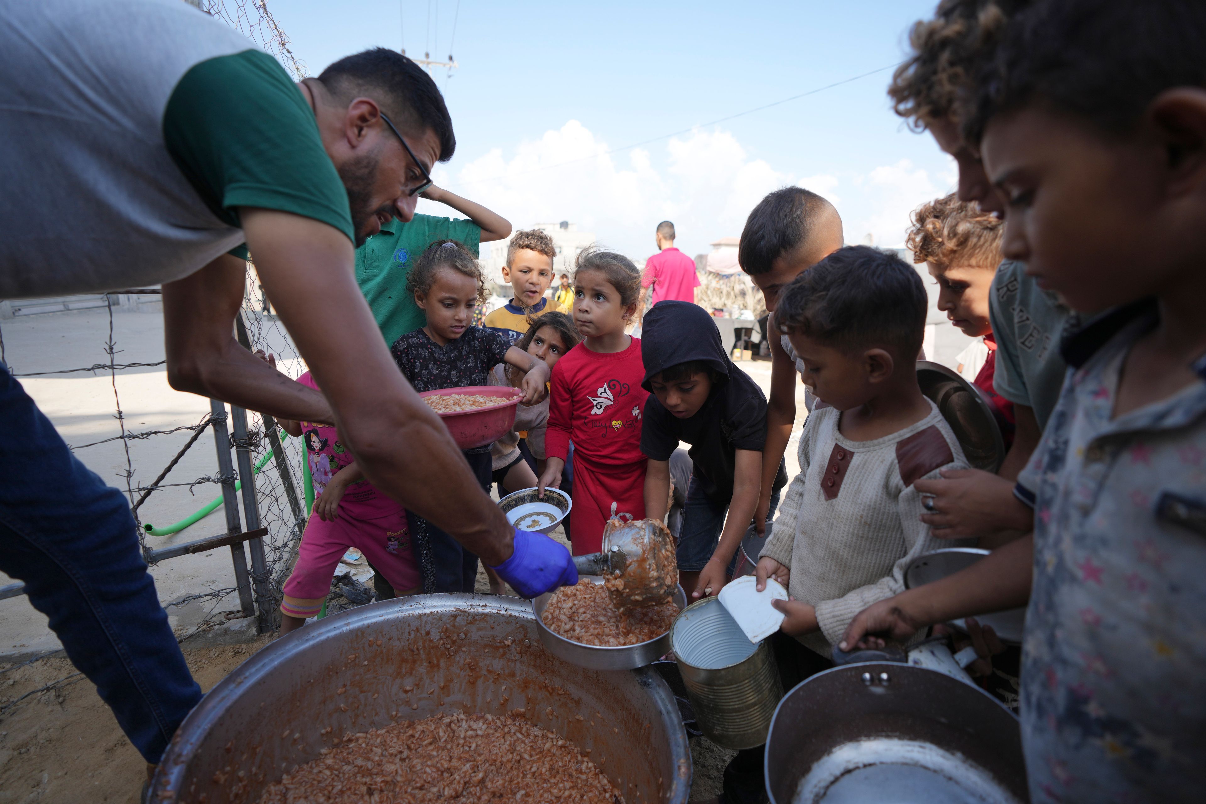 FILE - Displaced Palestinian children queue for food in a camp in Deir al-Balah, Gaza Strip, Friday, Oct. 18, 2024. (AP Photo/Abdel Kareem Hana, File)