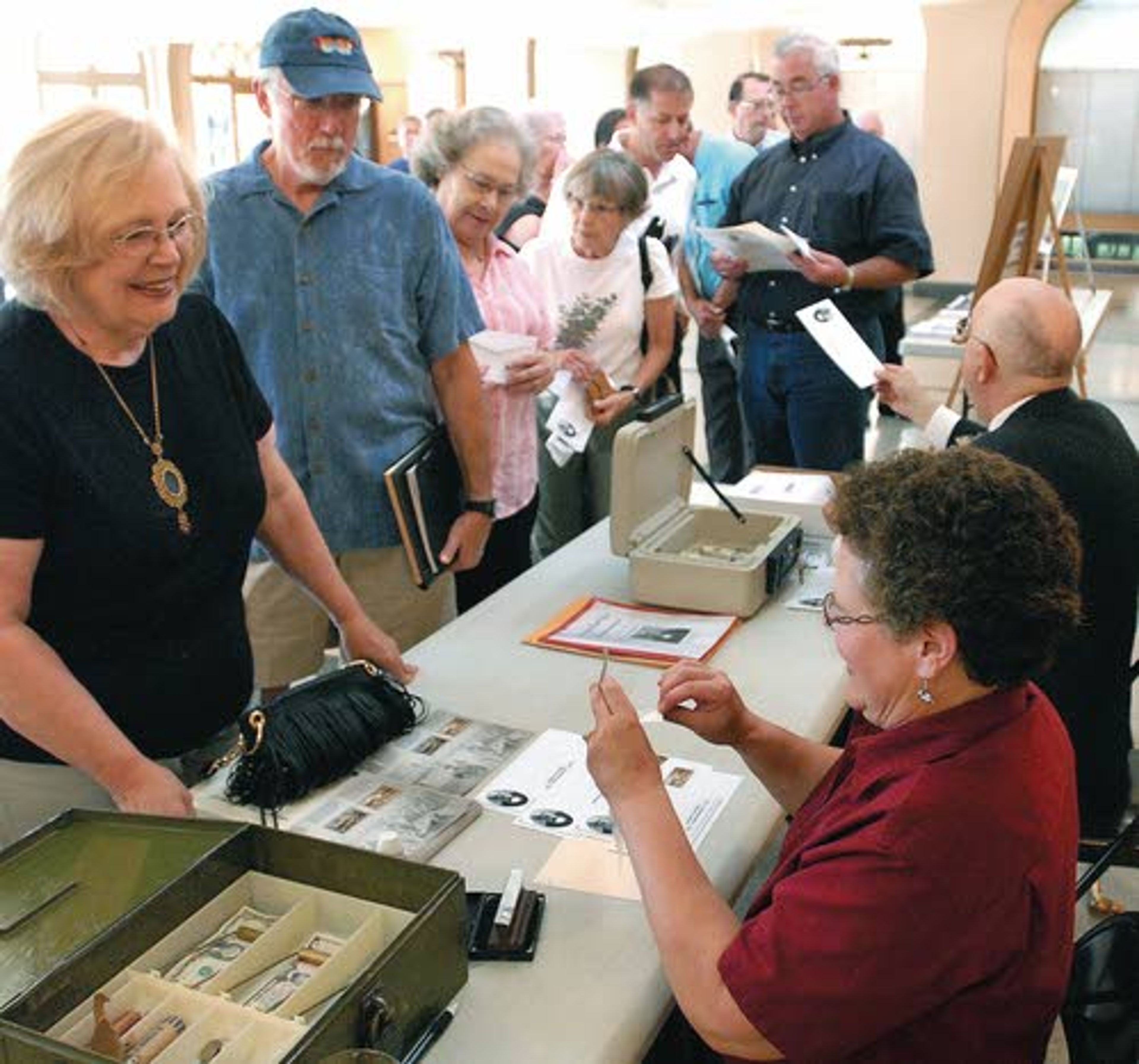 Troy Postmaster Linda Sundstrom (in maroon) and Steve Branting sell historical postal covers Wednesday with new- issue Civil War stamps and a special postmark (below) celebrating the 150th anniversary of postal service in Lewiston.