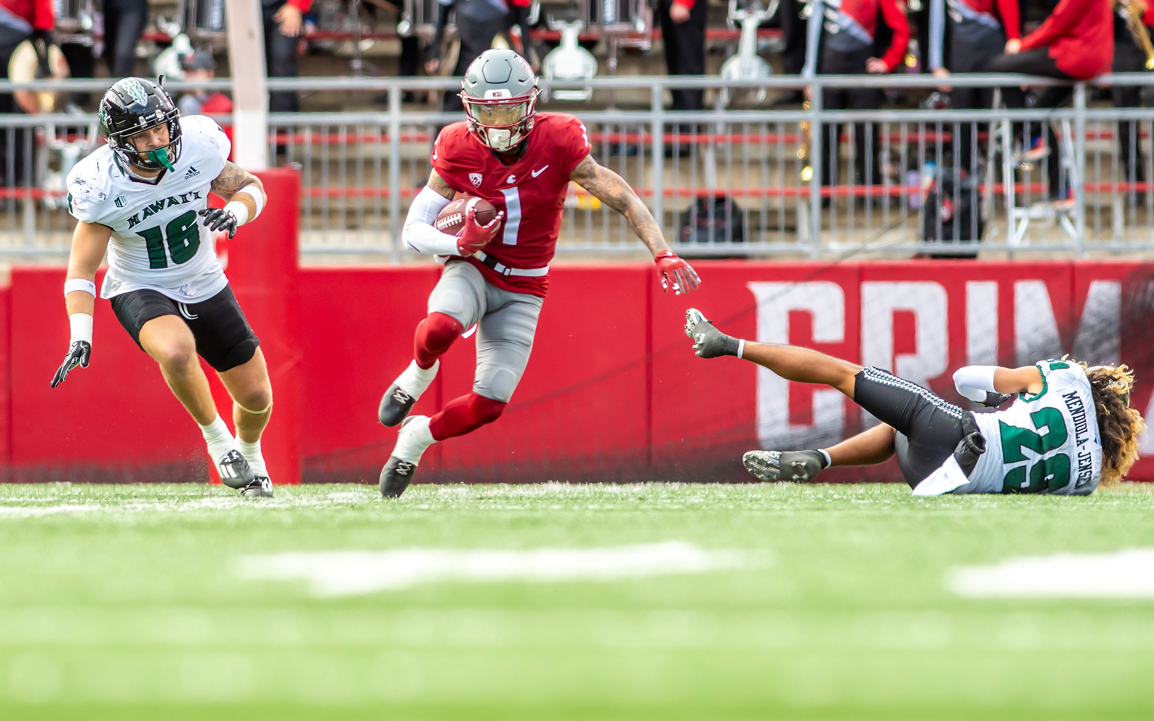 Washington State wide receiver Kris Hutson runs the ball down the field as Hawaii defensive back Kilinahe Mendiola-Jensen (29) misses a tackle in a college football game on Saturday at Gesa Field in Pullman.,