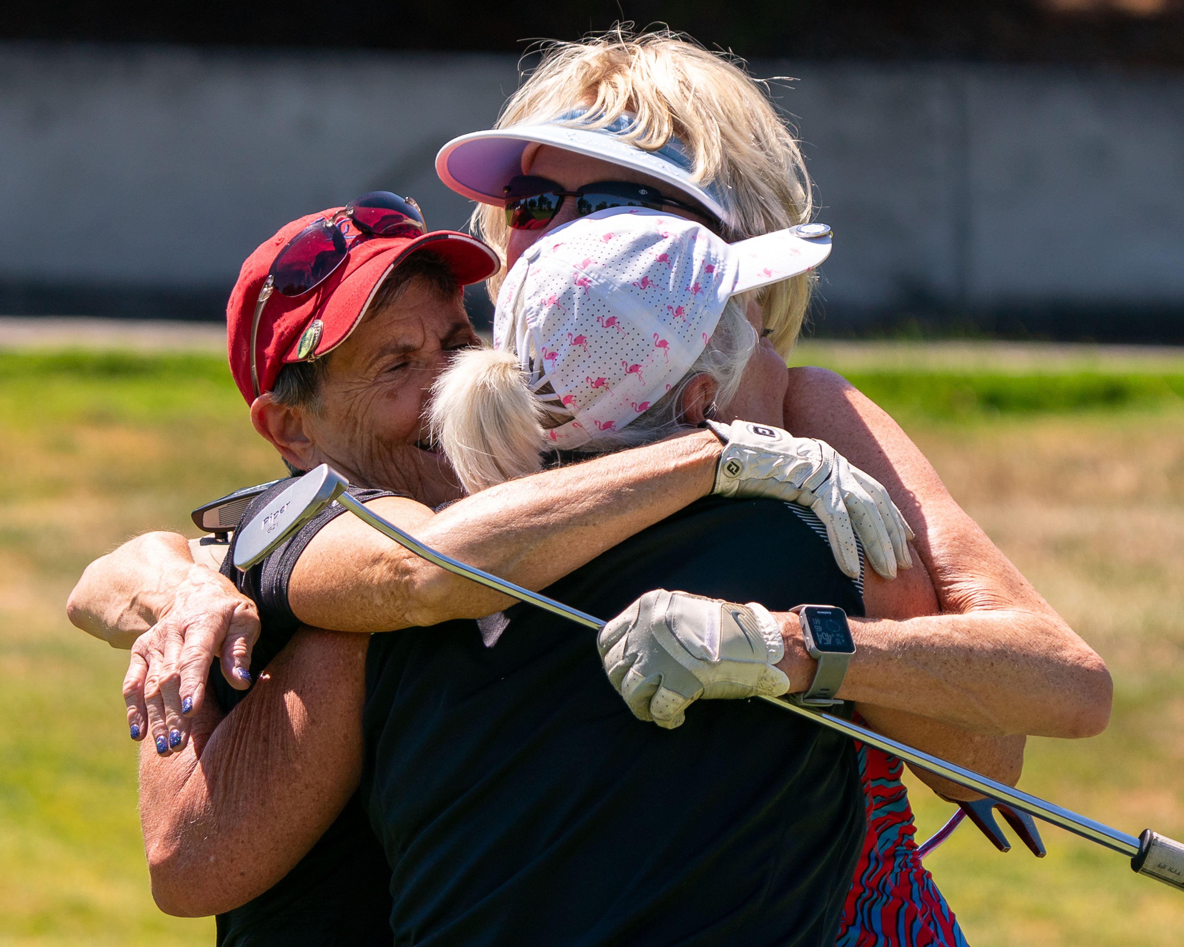 From left: Sharon Vahlkamp, Karen Haugen and Marcy Spilker hug each other after finishing the Tribune Cup women’s golf tournament on Tuesday at Red Wolf Golf Club in Clarkston.