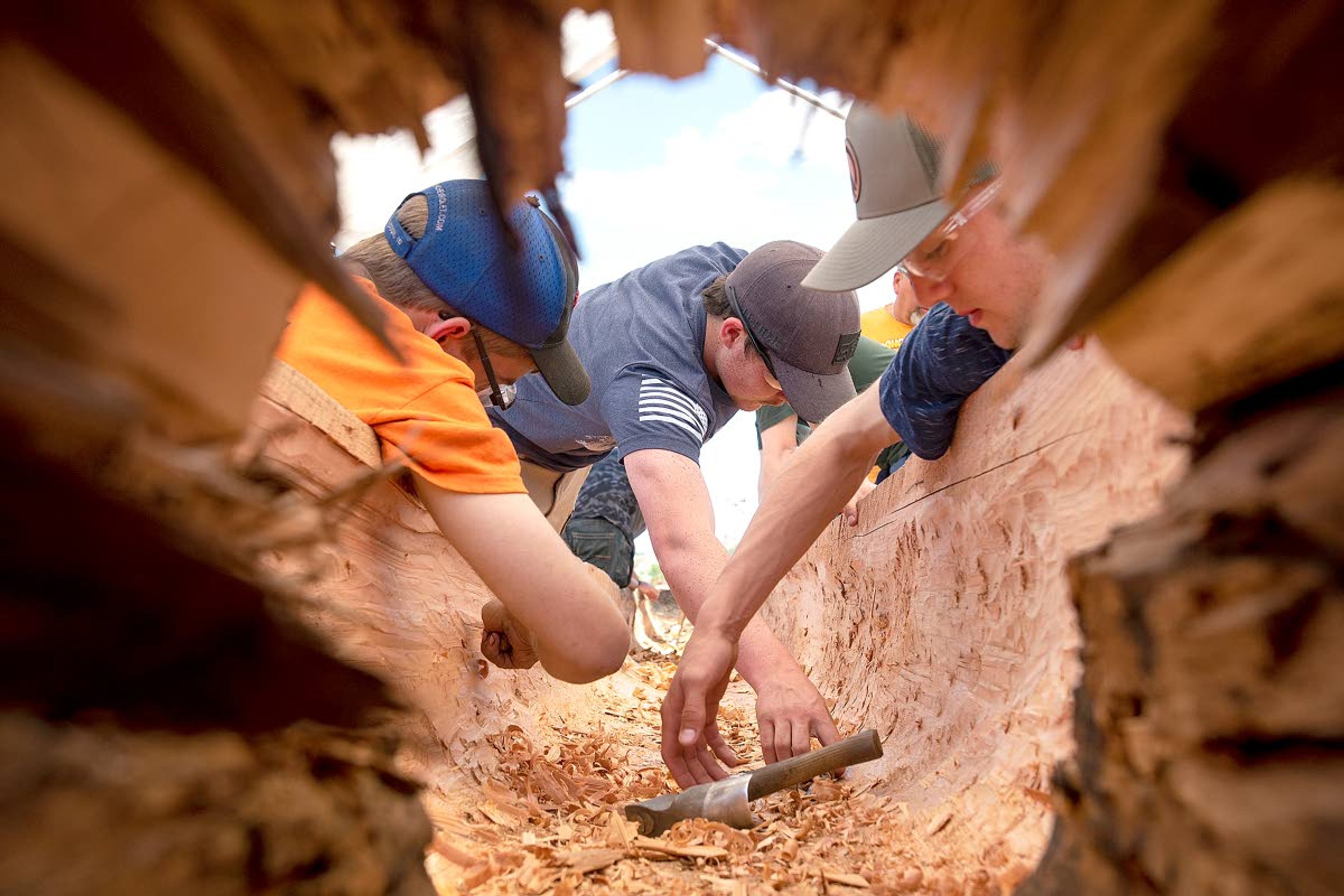 Students in Stuart Johnson’s third-year carpentry class at Lewiston High School work on hollowing out a large cedar log into a canoe Monday afternoon at Hells Gate State Park just south of Lewiston. The canoe will replace one currently on display behind the park’s Discovery Center.