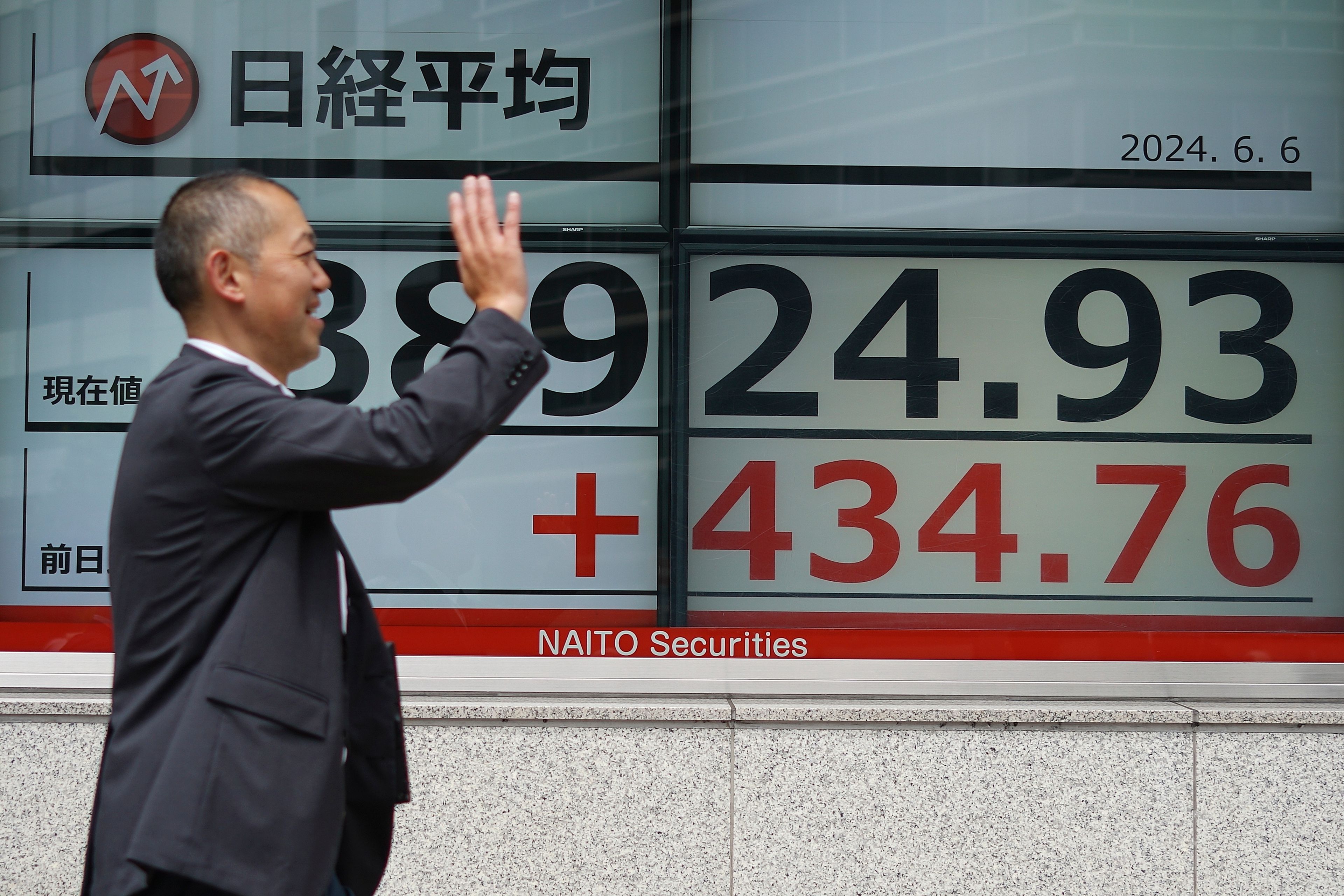 A person walks in front of an electronic stock board showing Japan's Nikkei 225 index at a securities firm Thursday, June 6, 2024, in Tokyo.