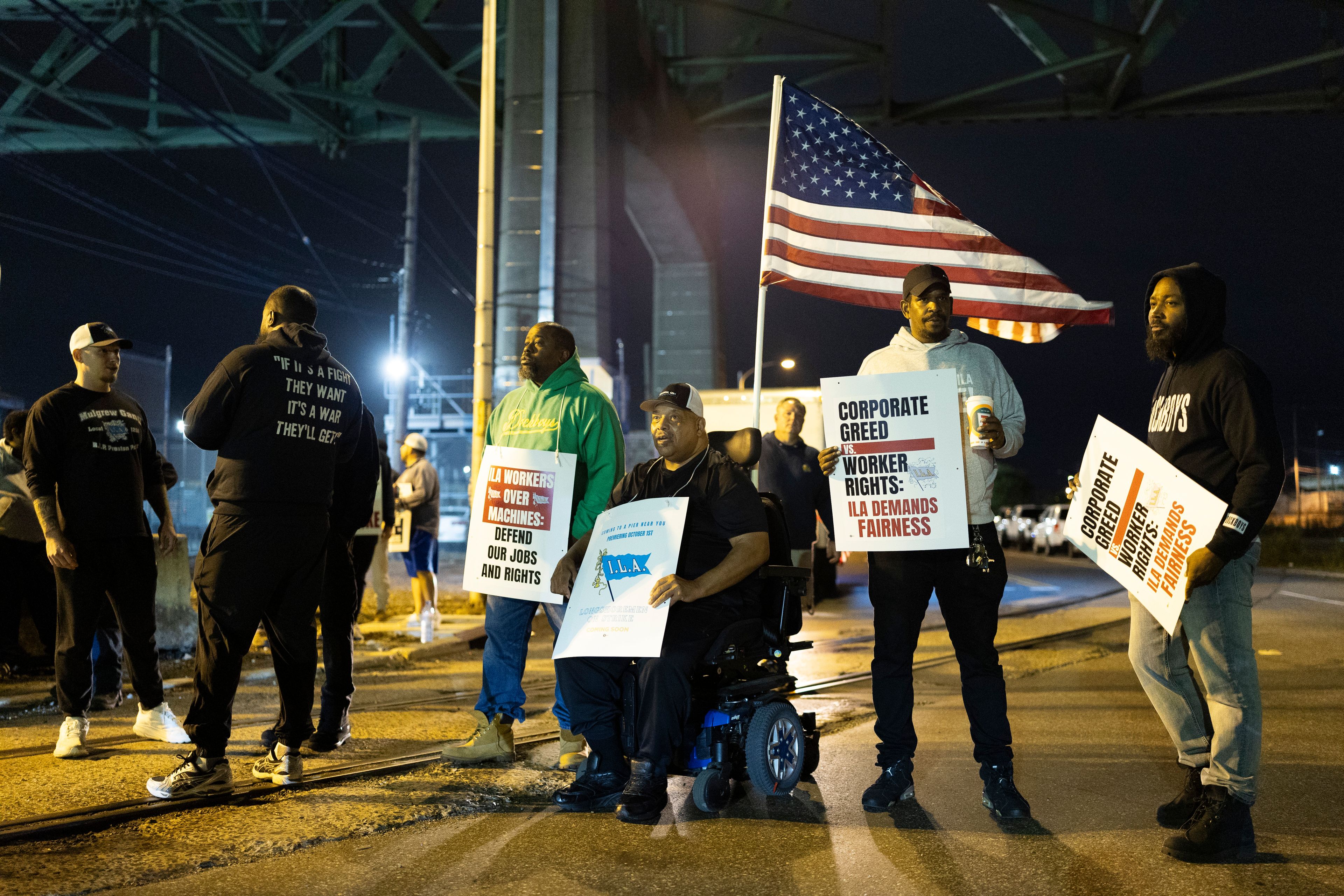 Boise Butler, president of Local 1291, with an American flag on his wheelchair, pickets with his fellow longshoremen outside the Packer Avenue Marine Terminal Port in Philadelphia, Tuesday, Oct. 1, 2024. (AP Photo/Ryan Collerd)