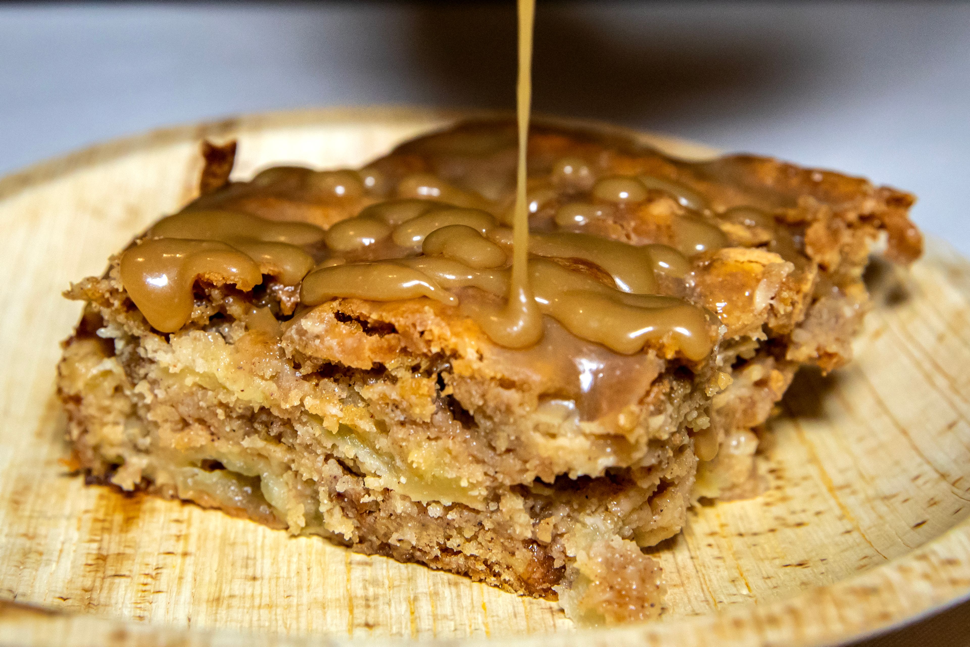 Butterscotch syrup is drizzled over an apple cake Thursday, Dec. 14, in Lewiston.