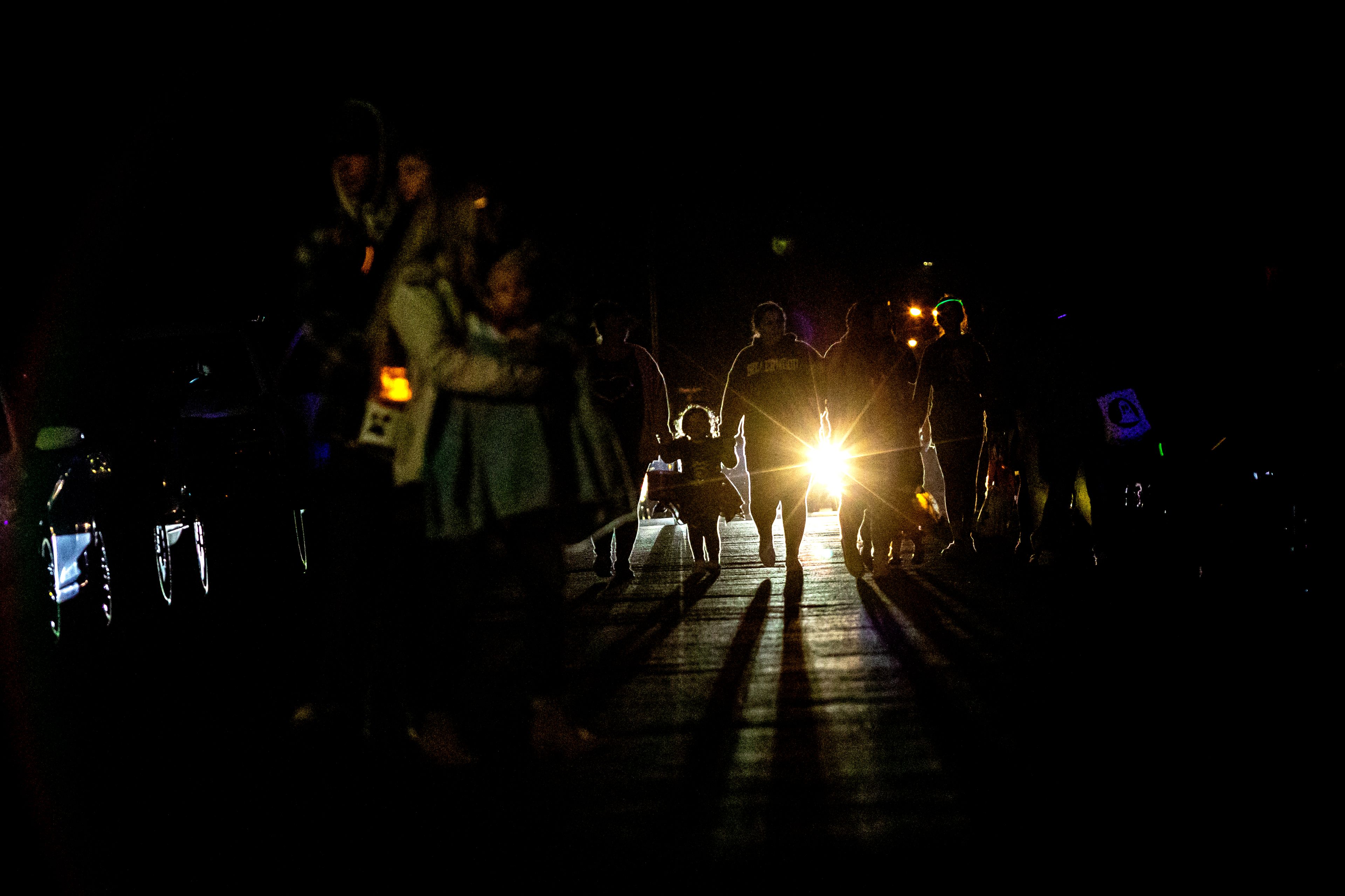 People walk with their kids through the streets on Halloween at the Birch neighborhood in the Lewiston Orchards on Monday.