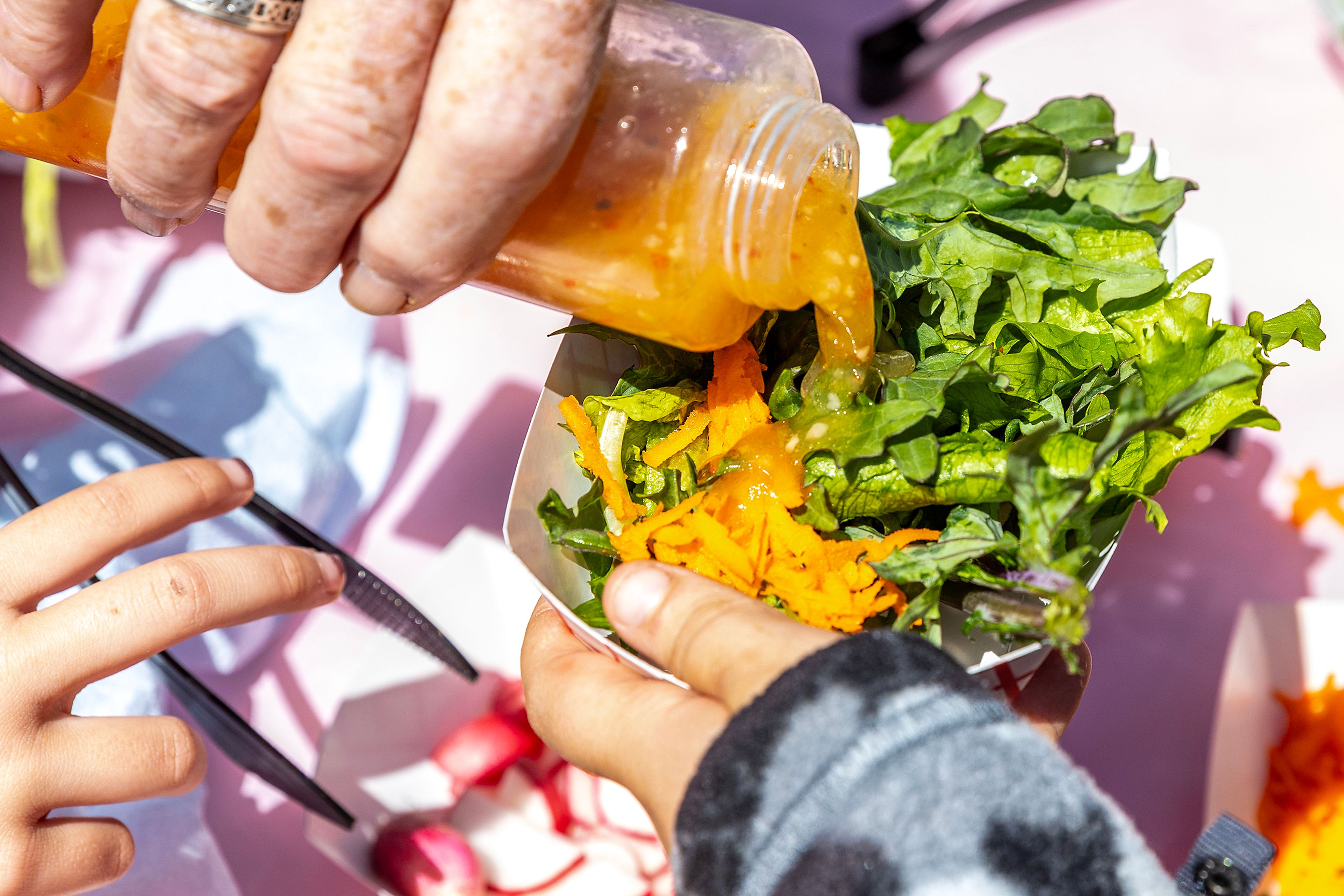 Italian dressing is added to a salad Monday at Grantham Elementary in Clarkston.