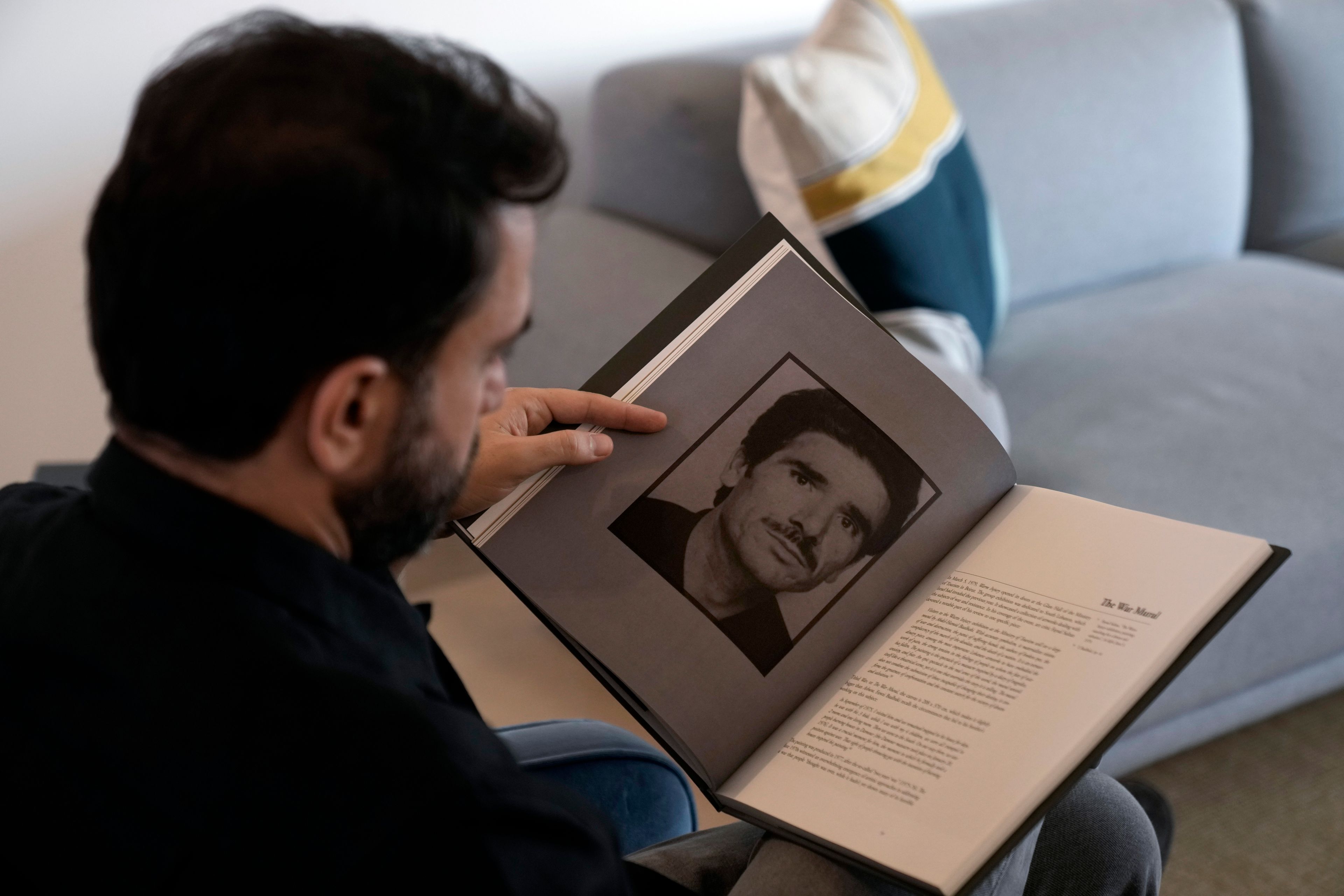 Lubnan Baalbaki shows a picture of his late father during an interview with The Associated Press at his house in Geitawi, Beirut, Lebanon, Thursday, Oct. 31, 2024. (AP Photo/Bilal Hussein)