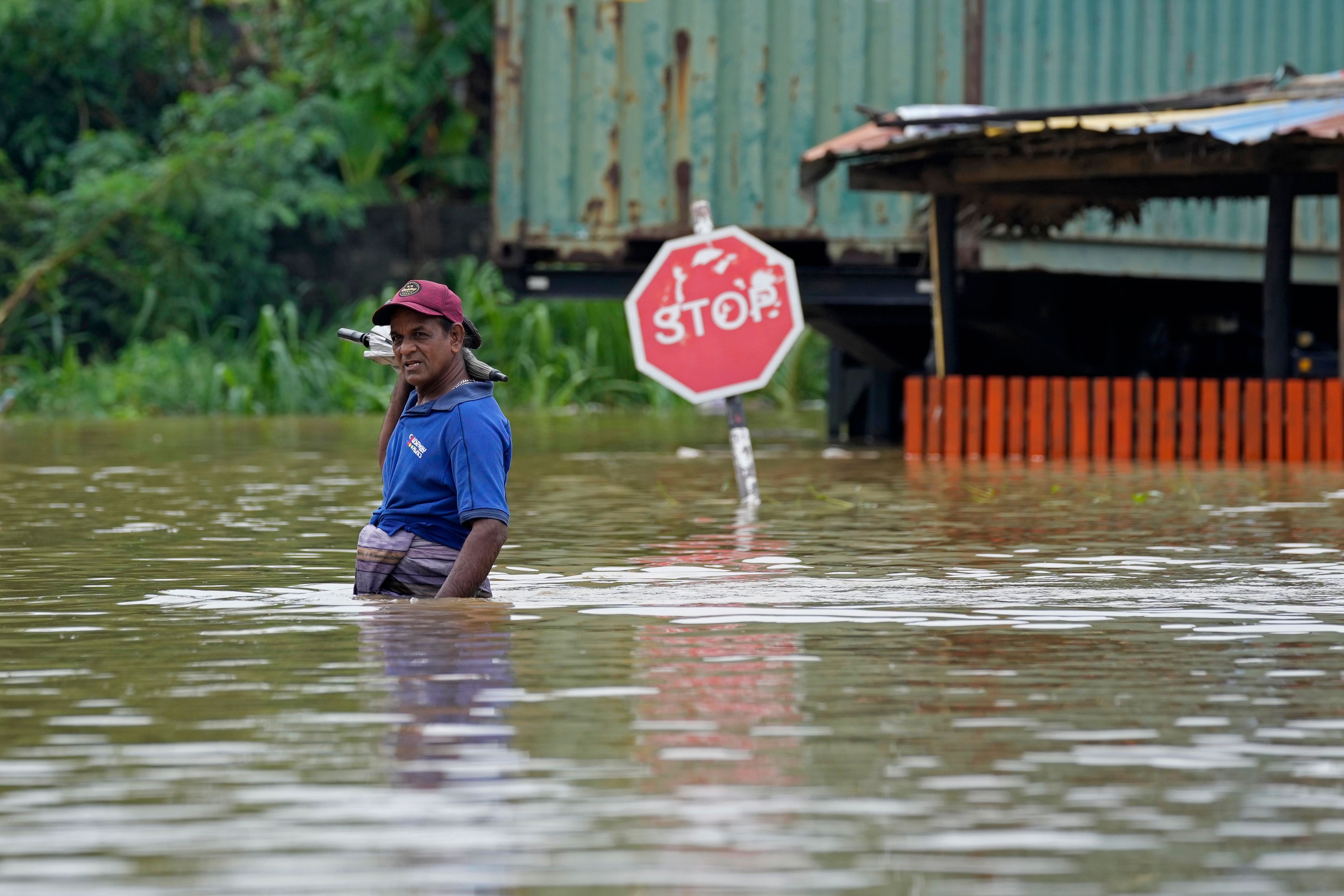 A man wades through flood waters in Kelaniya, a suburb of Colombo, Sri Lanka, Monday, June 3, 2024. Sri Lanka closed schools on Monday as heavy rains triggered floods and mudslides in many parts of the island nation, killing at least 10 people while six others have gone missing, officials said.