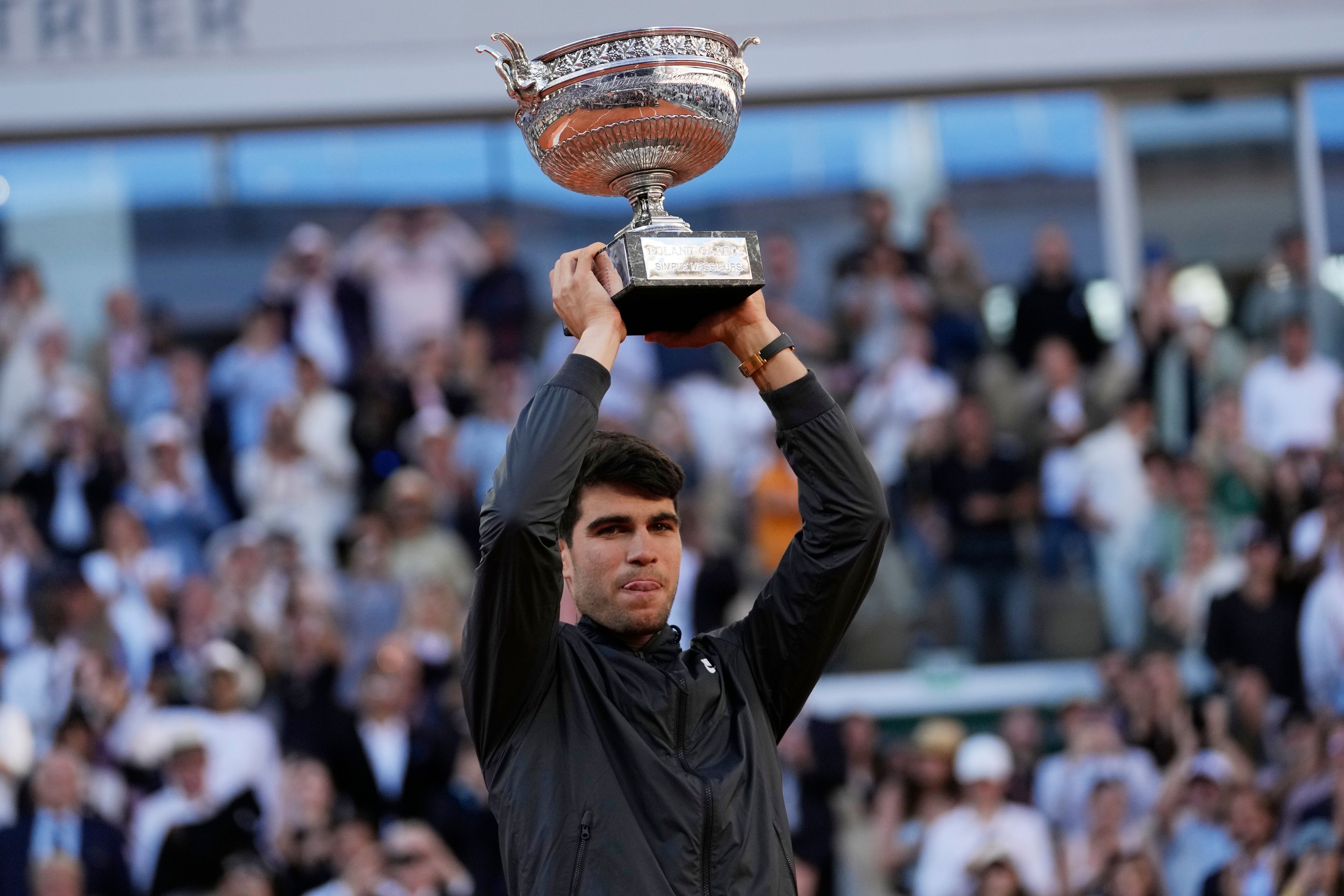 Winner Spain's Carlos Alcaraz celebrates with the trophy as he won the men's final match of the French Open tennis tournament against Germany's Alexander Zverev at the Roland Garros stadium in Paris, Sunday, June 9, 2024.